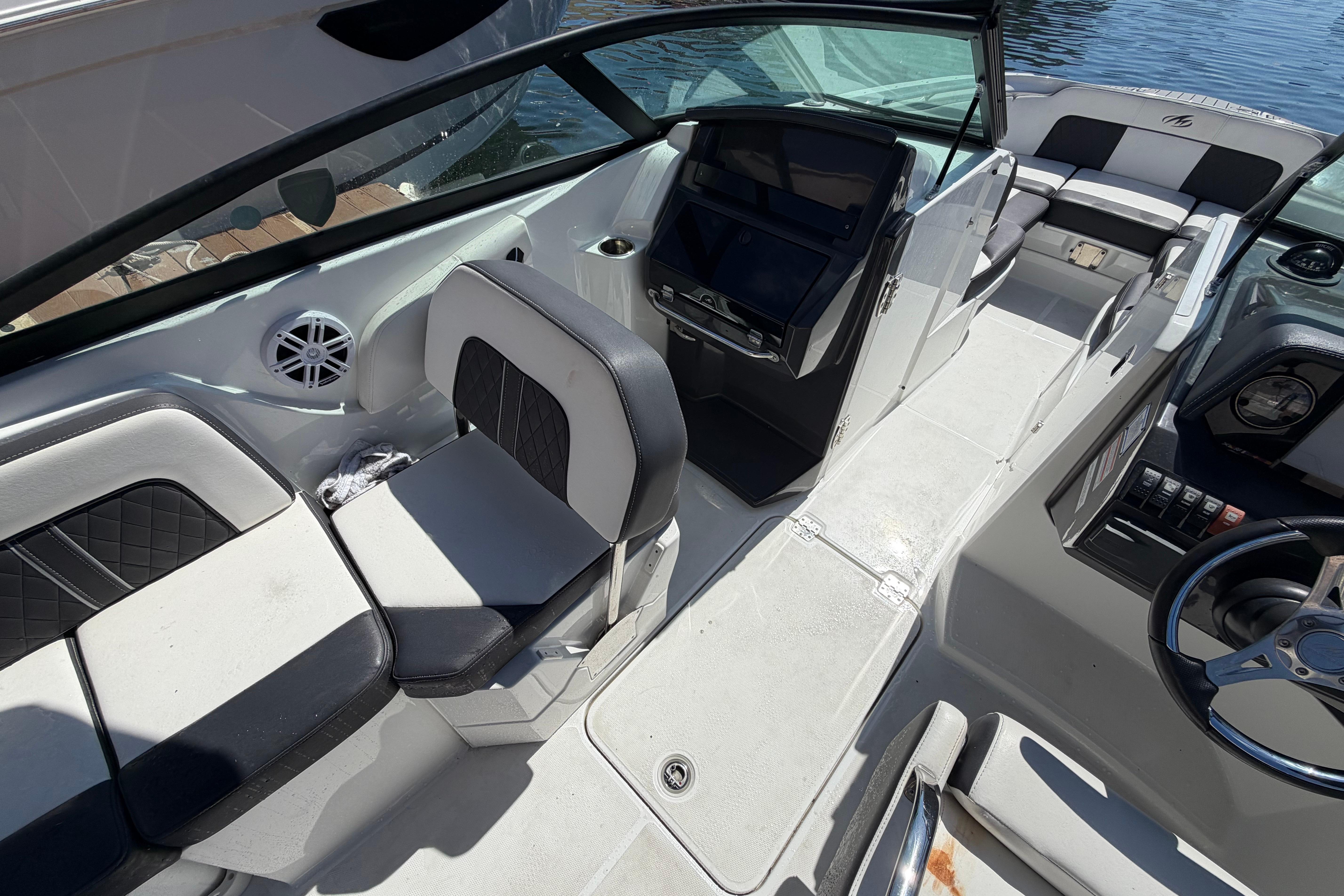 2022 Monterey M-65 boat interior with modern seating and steering wheel, docked by water.