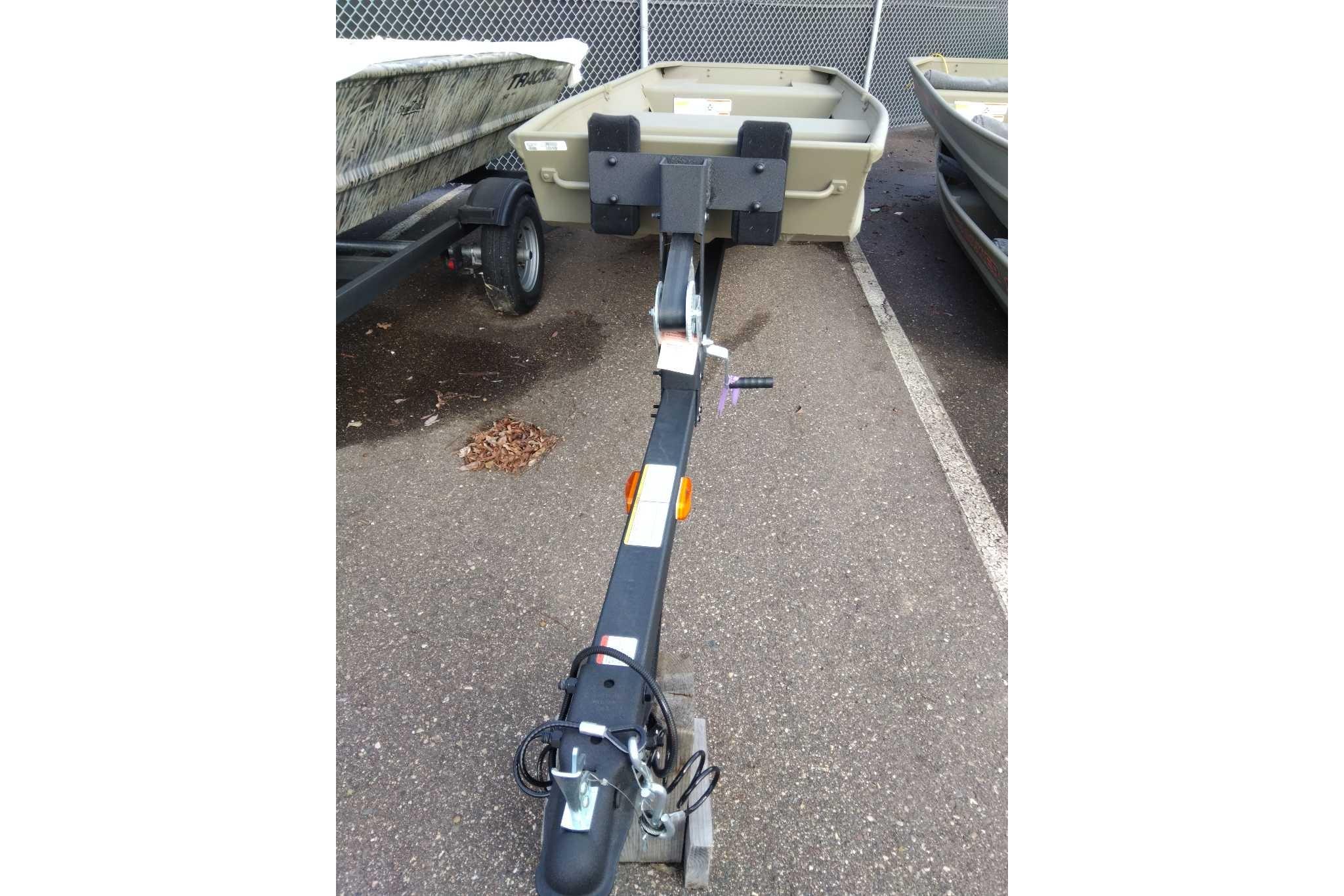 2026 Tracker Grizzly 14 Jon boat on trailer in parking lot.