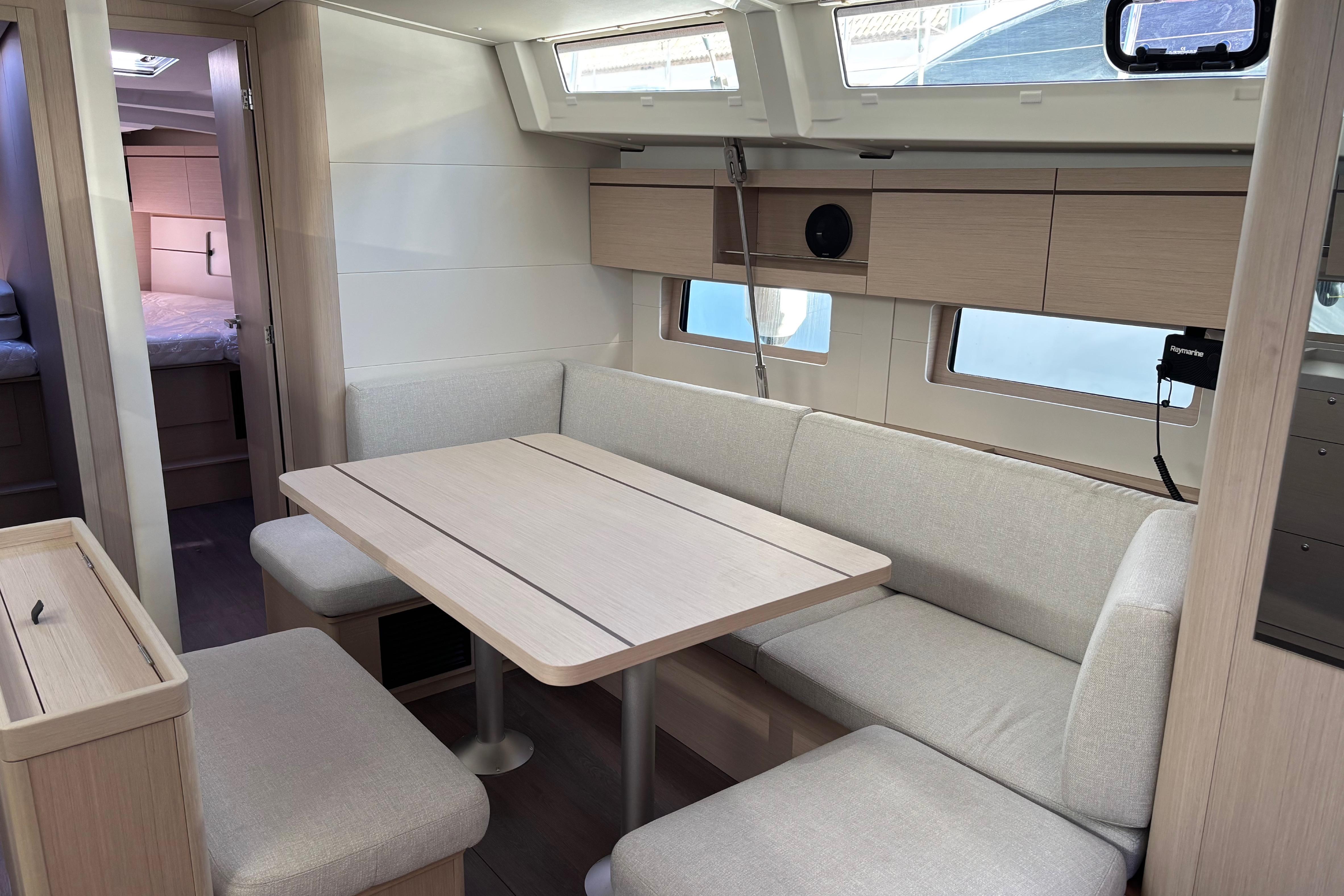 Interior of 2023 Beneteau Oceanis 46.1 yacht, featuring a modern dining area with light wood finishes.