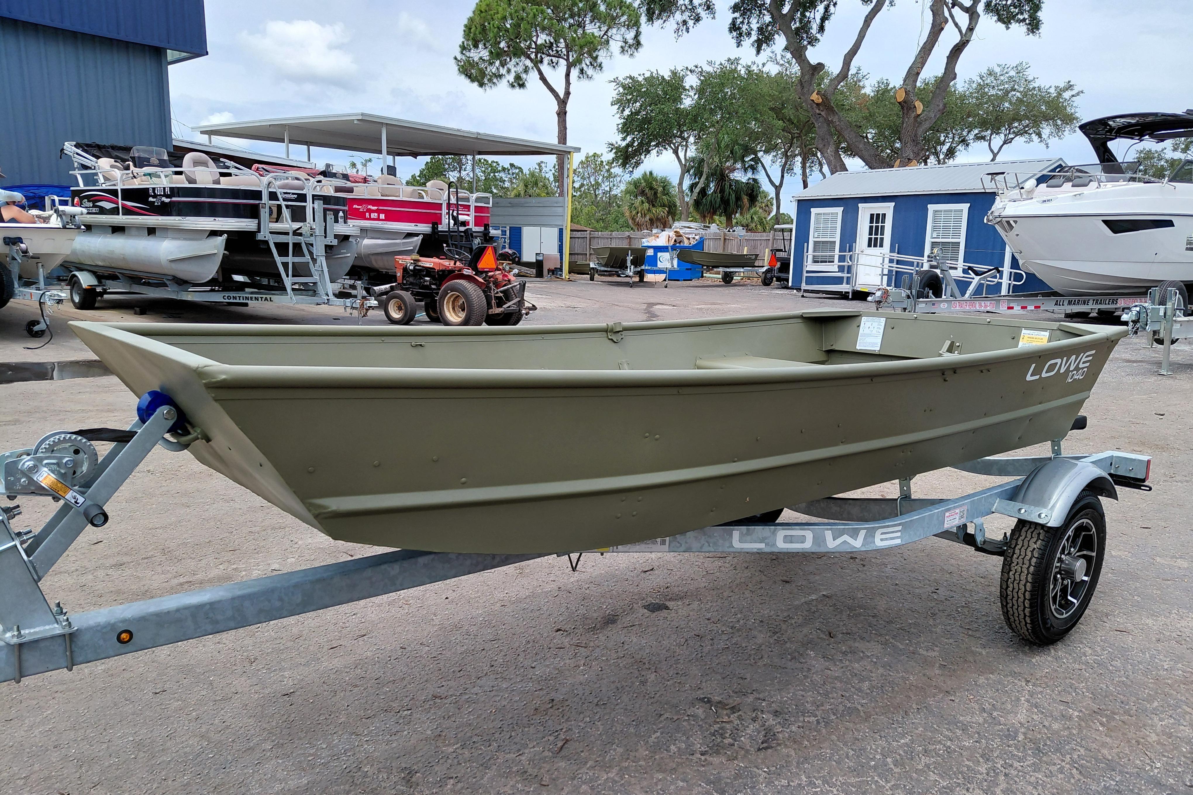 2025 Lowe L1040 Jon boat on trailer at a dealership, surrounded by other boats.