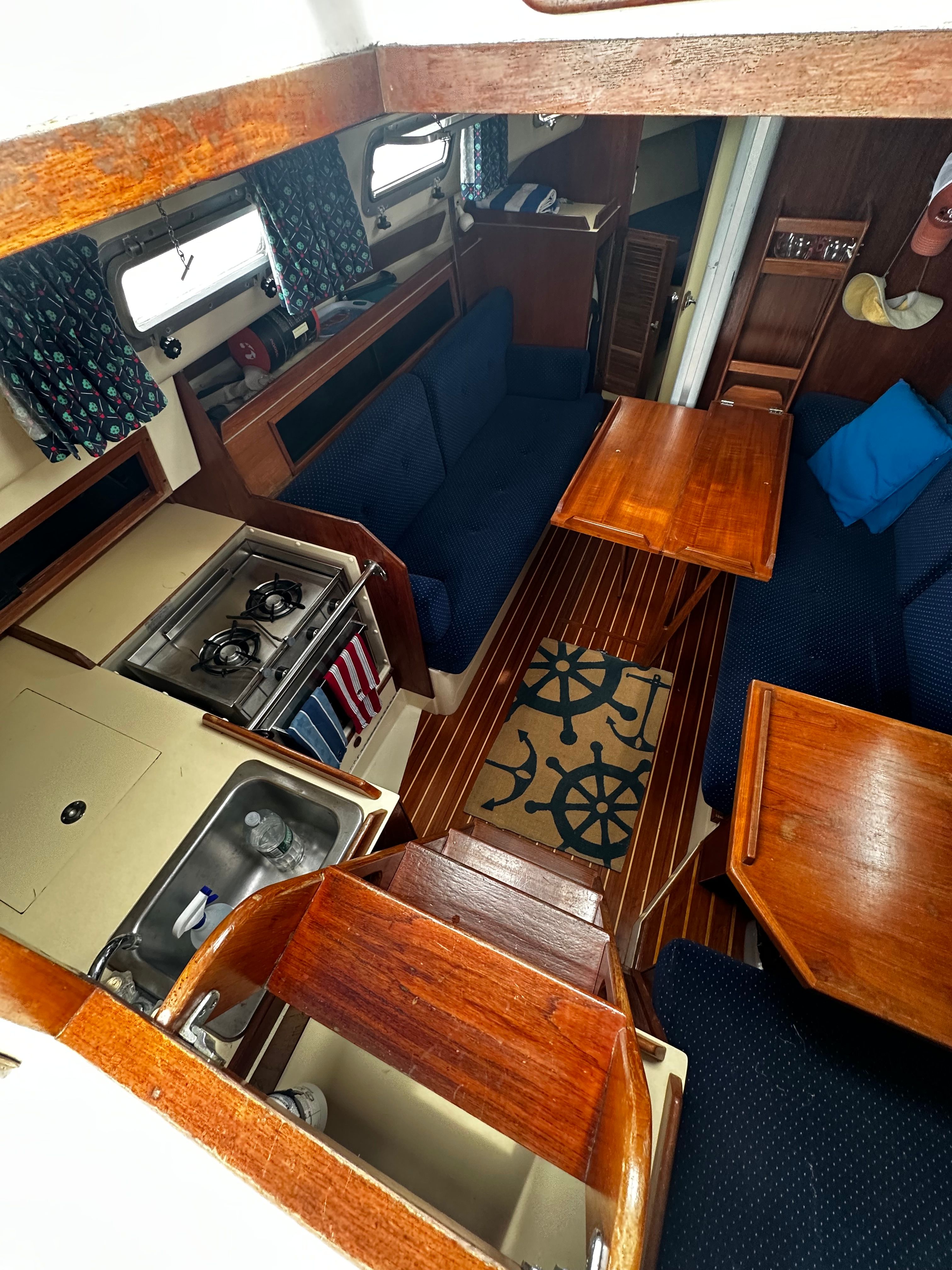 Interior of a 1984 Pearson 303 sailboat with wooden furnishings and a galley.
