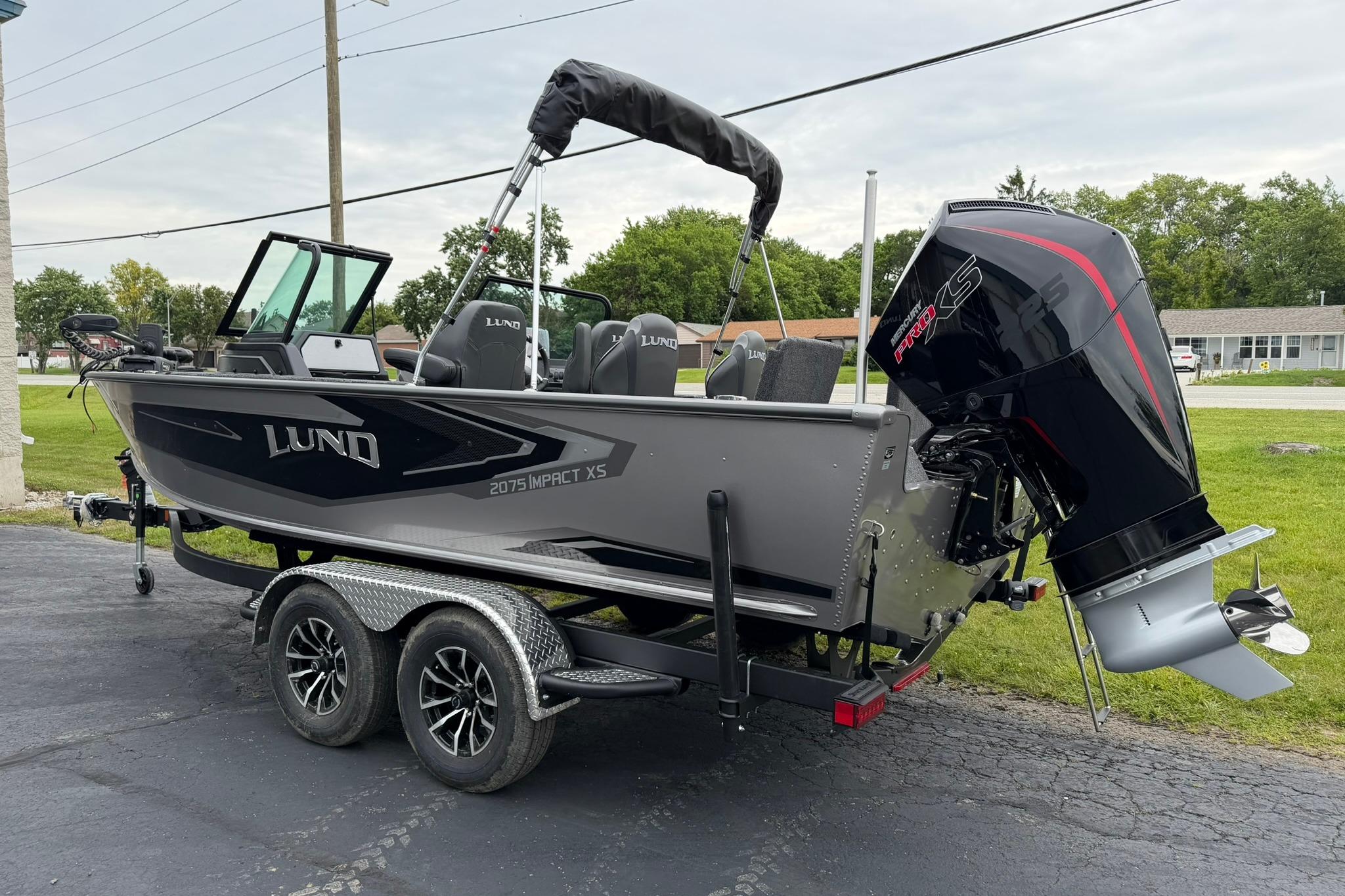 2027 Lund 2075 Impact XS boat on trailer with powerful outboard motor.