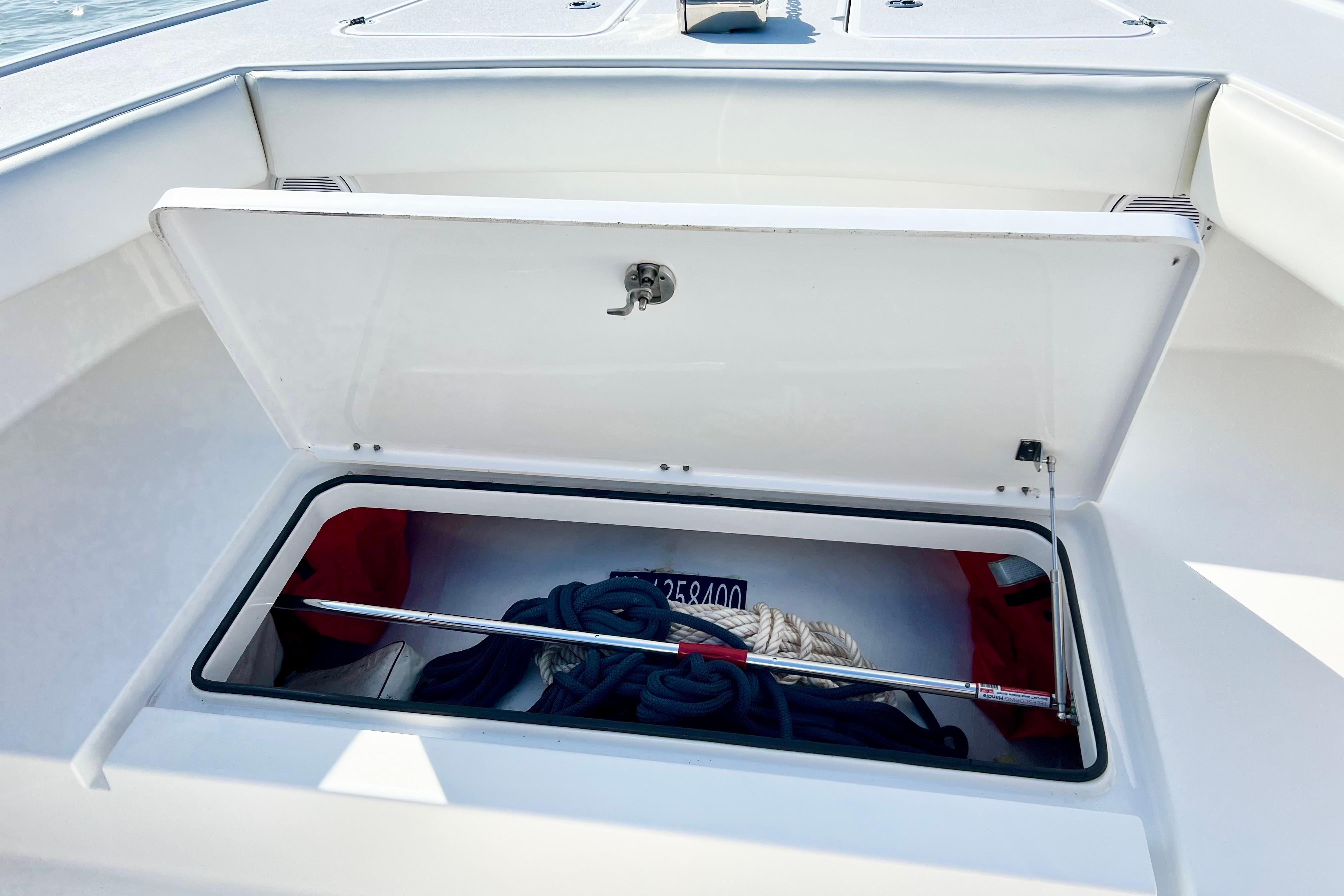 Open storage compartment on 2015 Freeman 34VH boat with ropes and equipment.