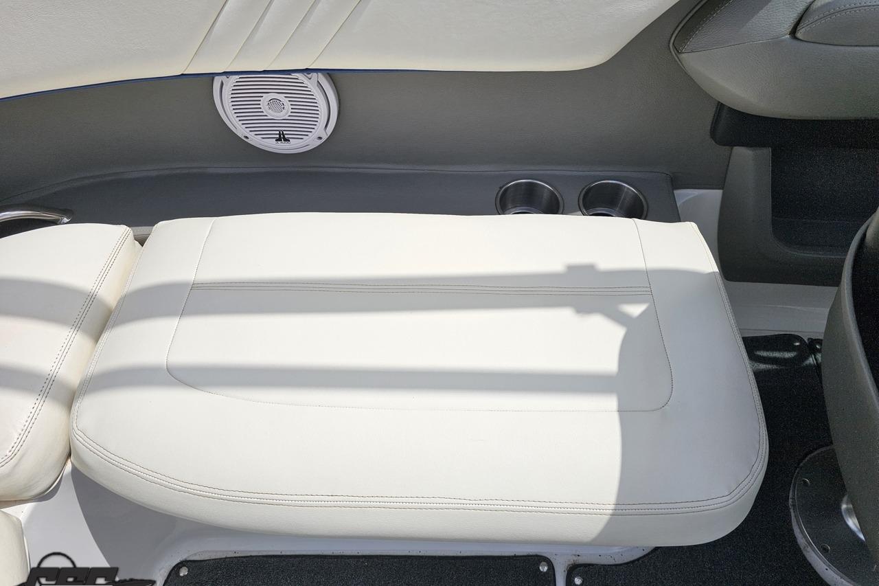 Interior of 2010 Cobalt 232 WSS boat with white seating and speaker.