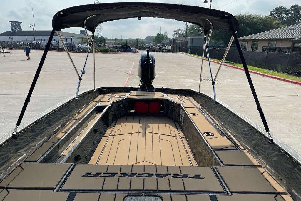 2026 Tracker Grizzly 1756 T Marsh boat with canopy in a parking area.