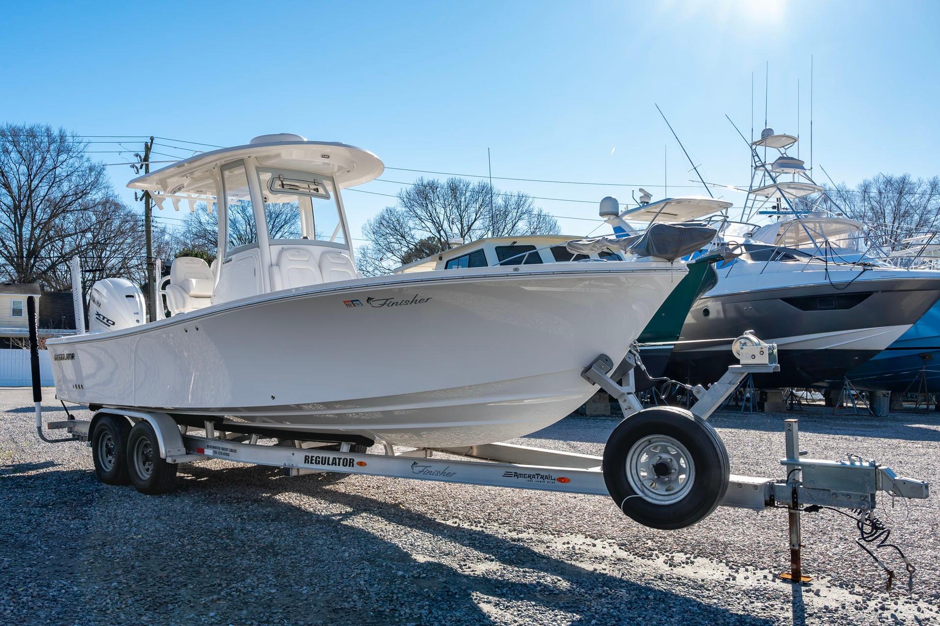 2024 Regulator 26XO boat on trailer, parked outdoors under clear sky.