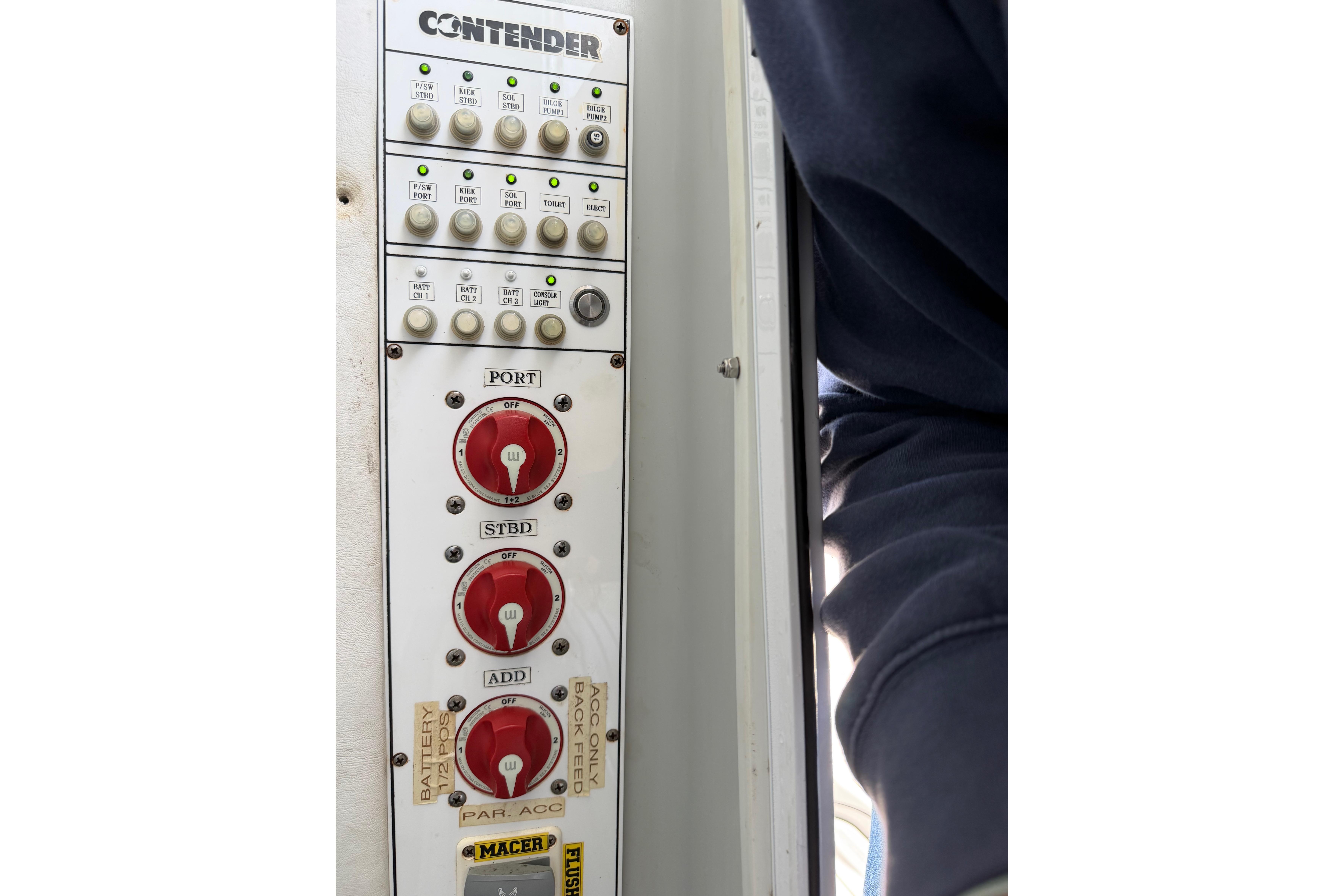 Control panel of a 2015 Contender 32 ST boat with switches and dials.