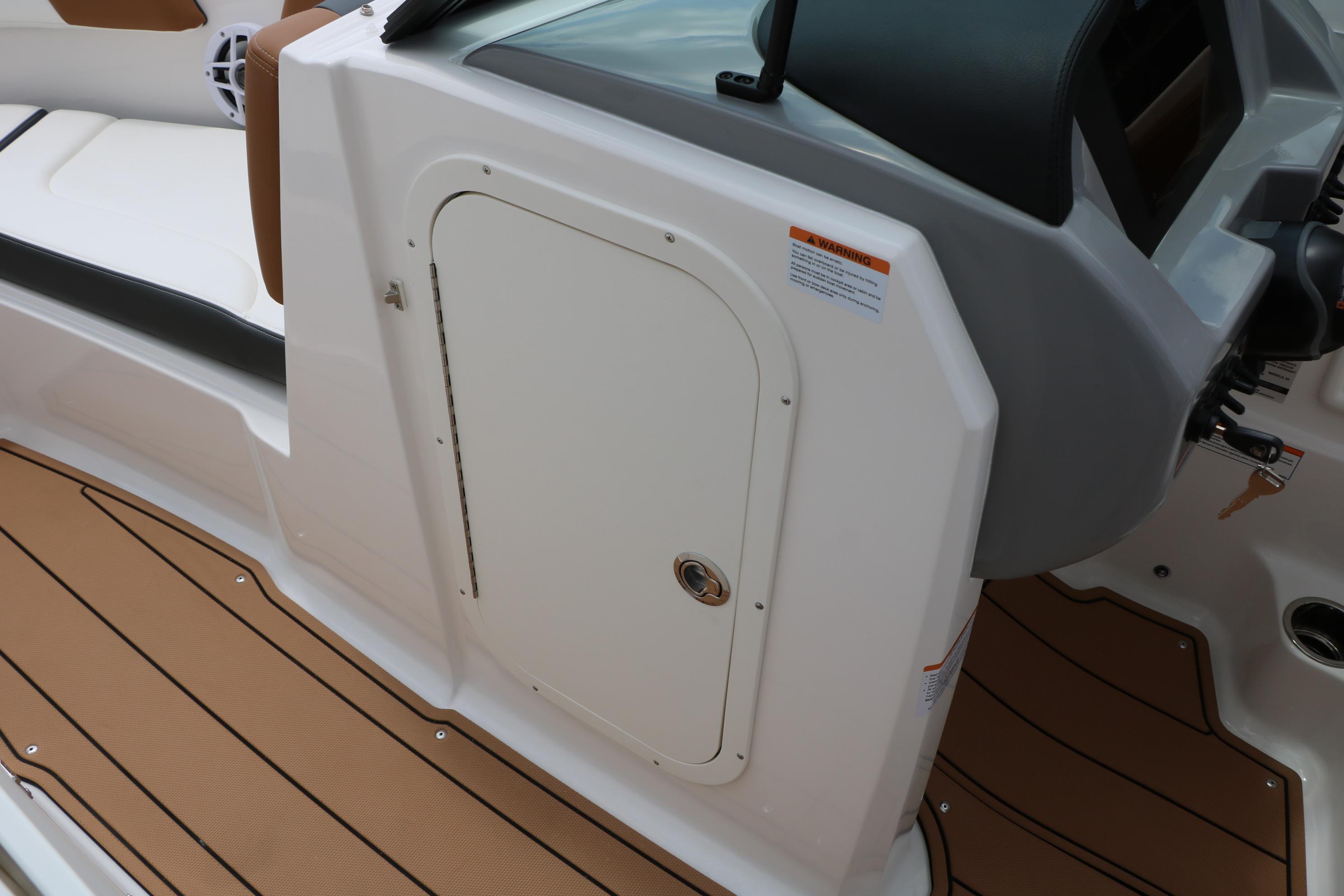 2025 Chaparral 23 SSi boat interior with brown flooring and white seating.