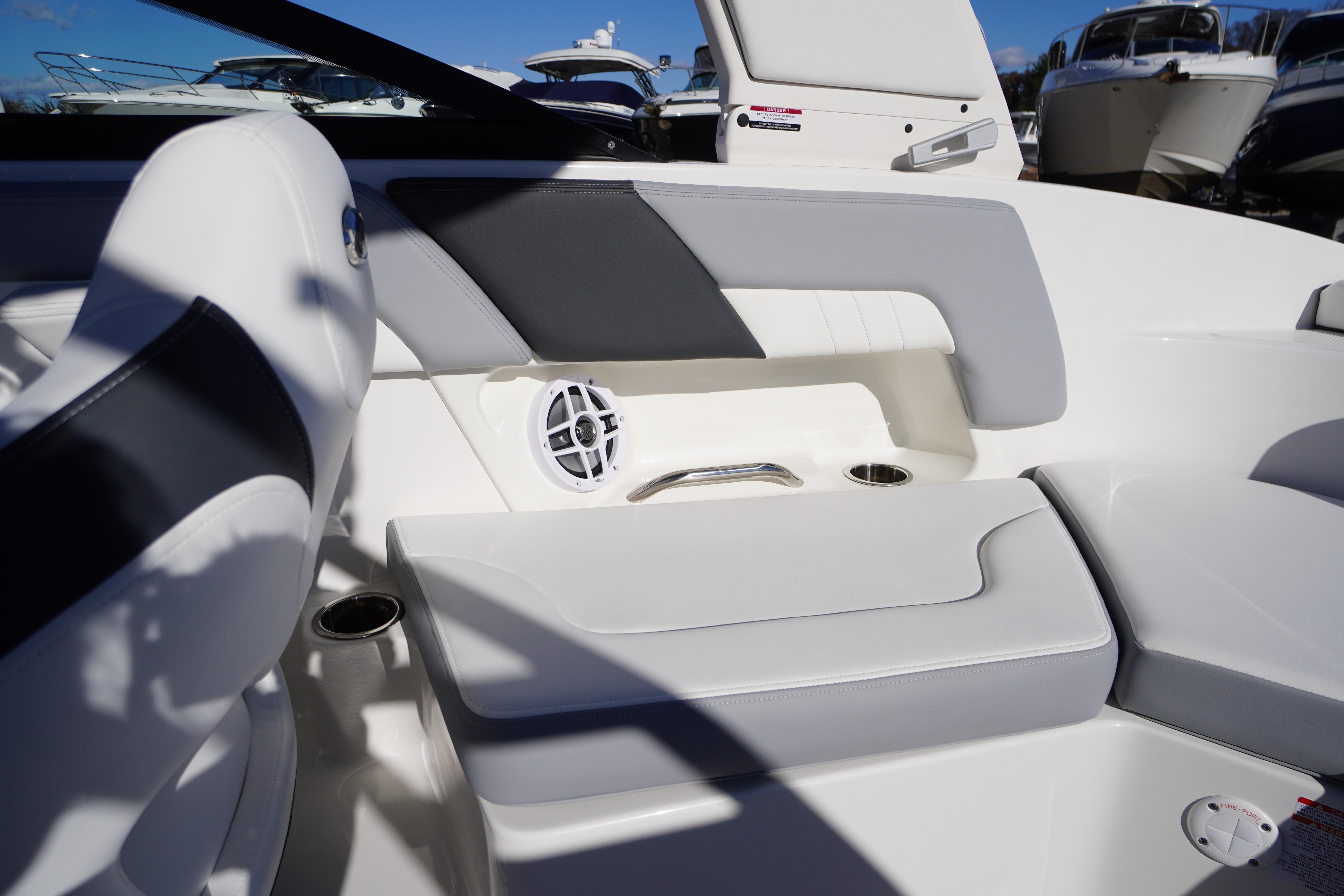 2026 Chaparral 23 SSi boat interior with white and gray seating, cup holders, and speaker.