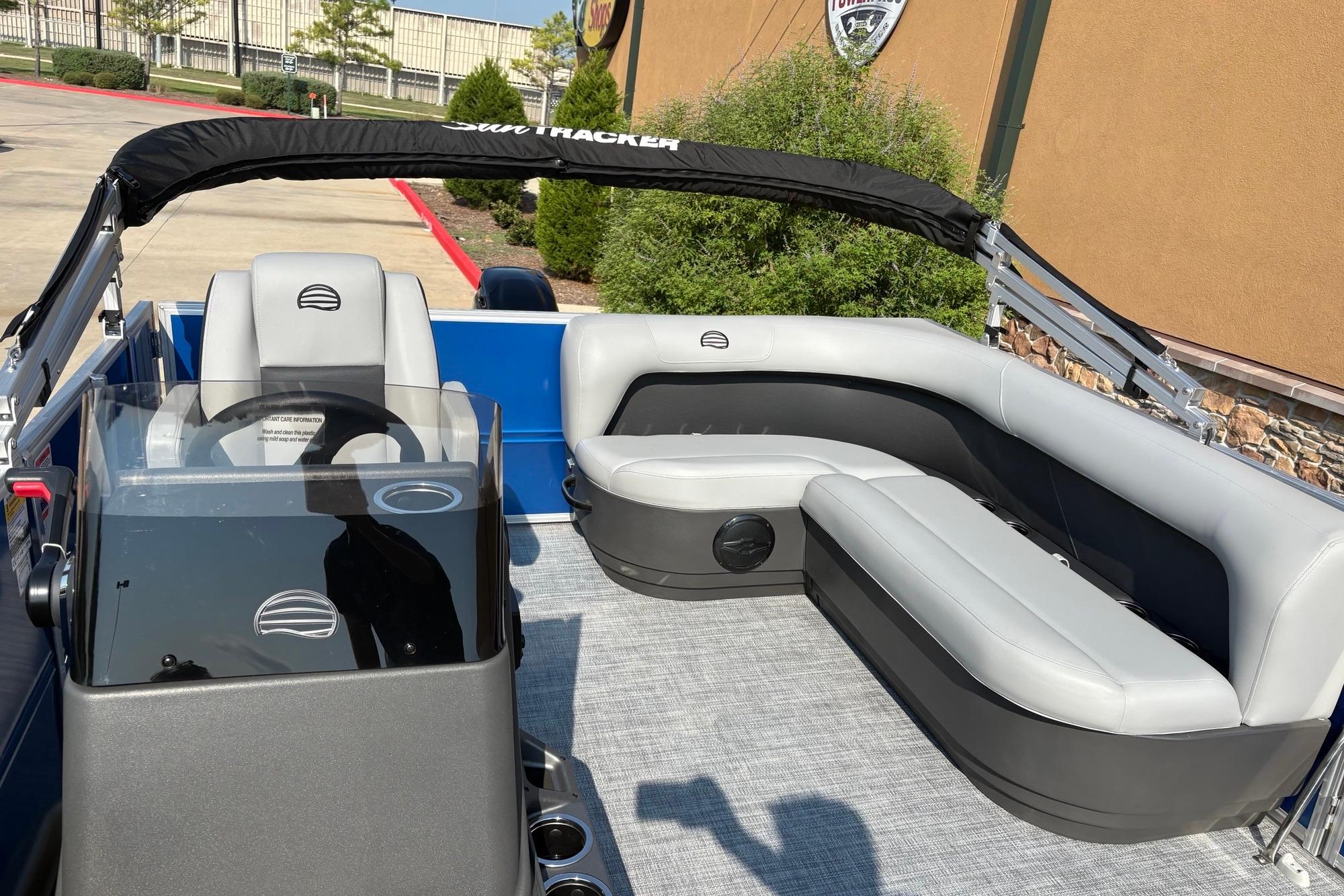2026 Sun Tracker Party Barge 16 DLX interior with gray seating and steering console.