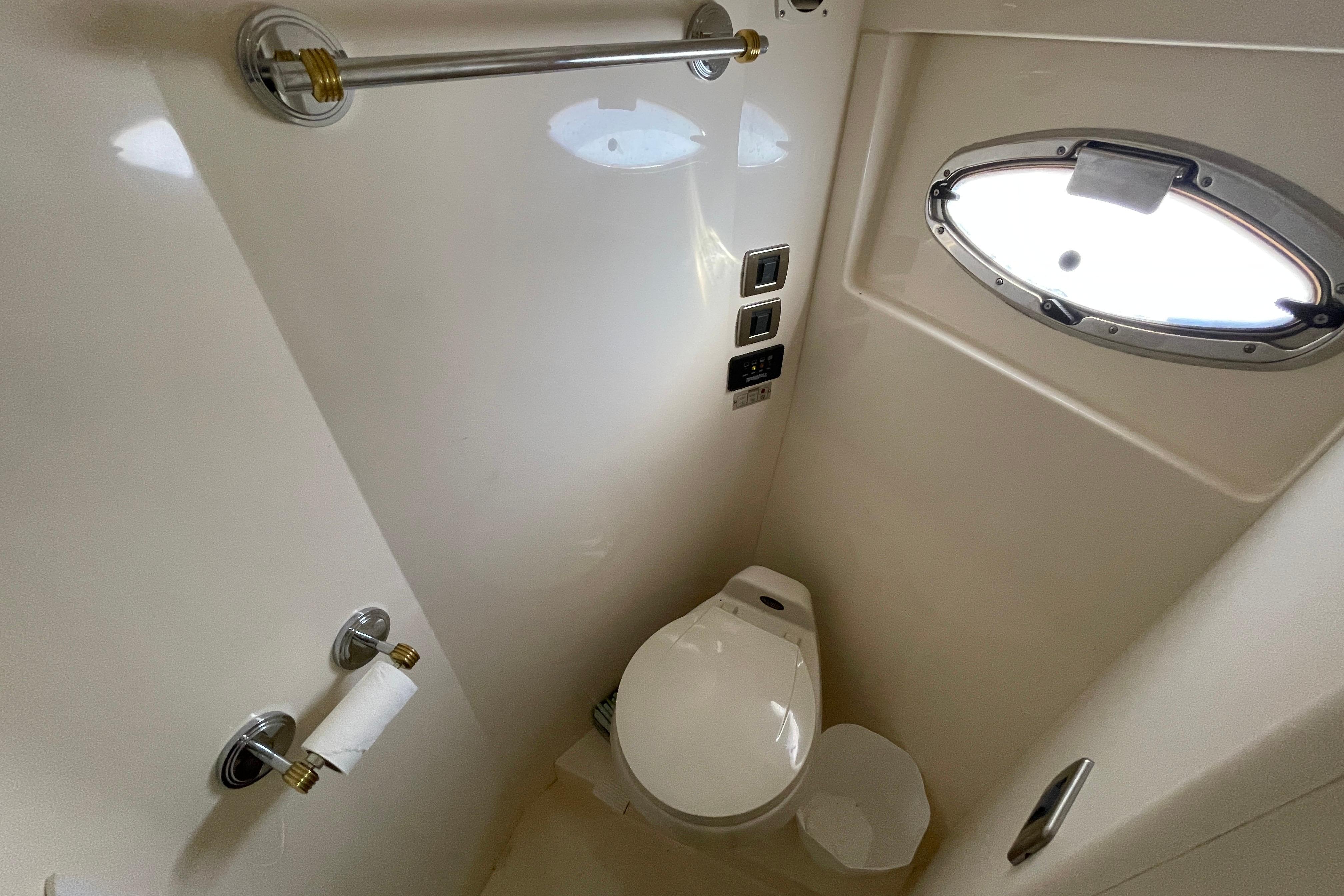 Bathroom interior of 2002 Carver 570 Voyager Pilothouse with porthole and toilet.
