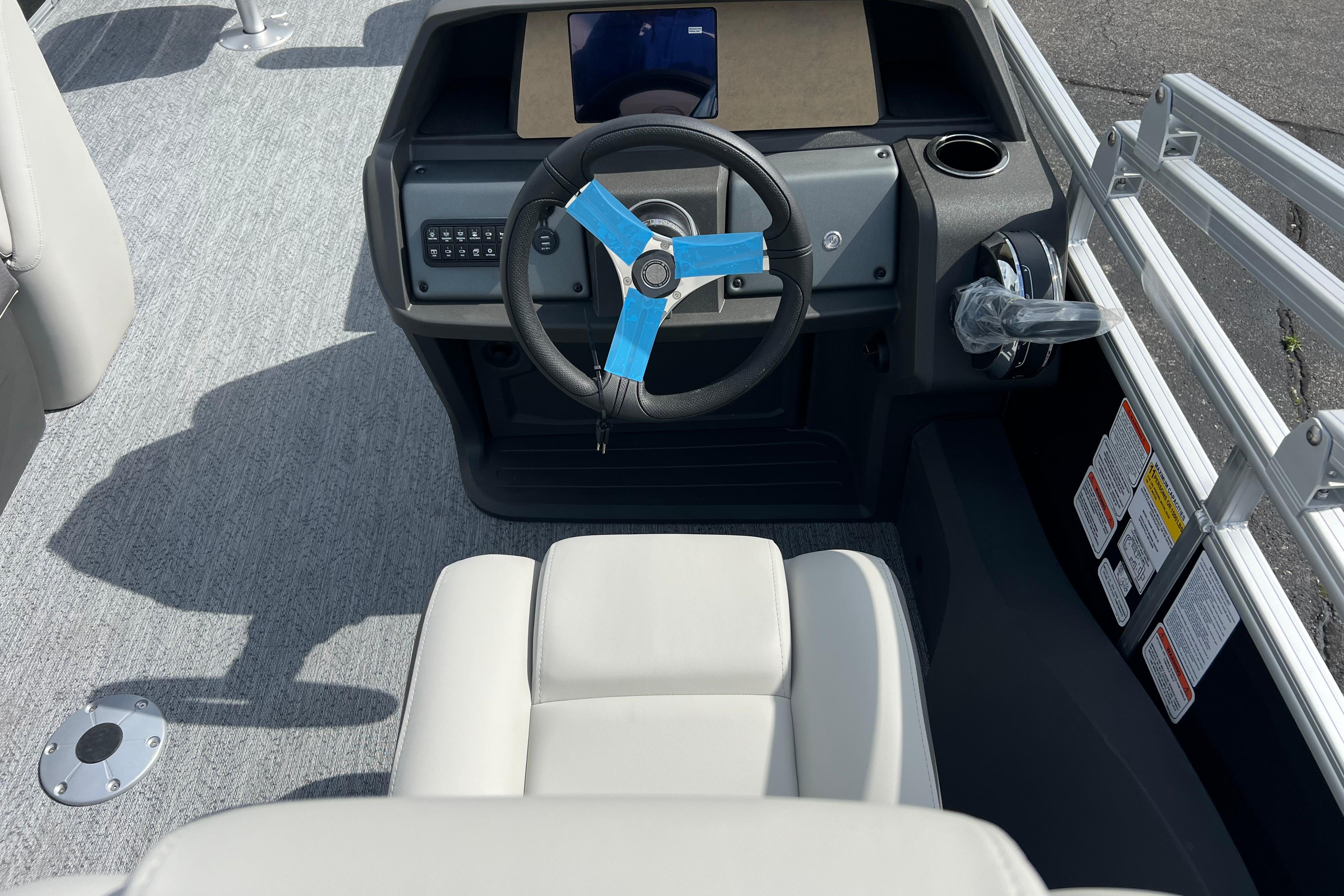 2026 Sun Tracker Fishin' Barge 22 DLX helm with steering wheel and control panel.