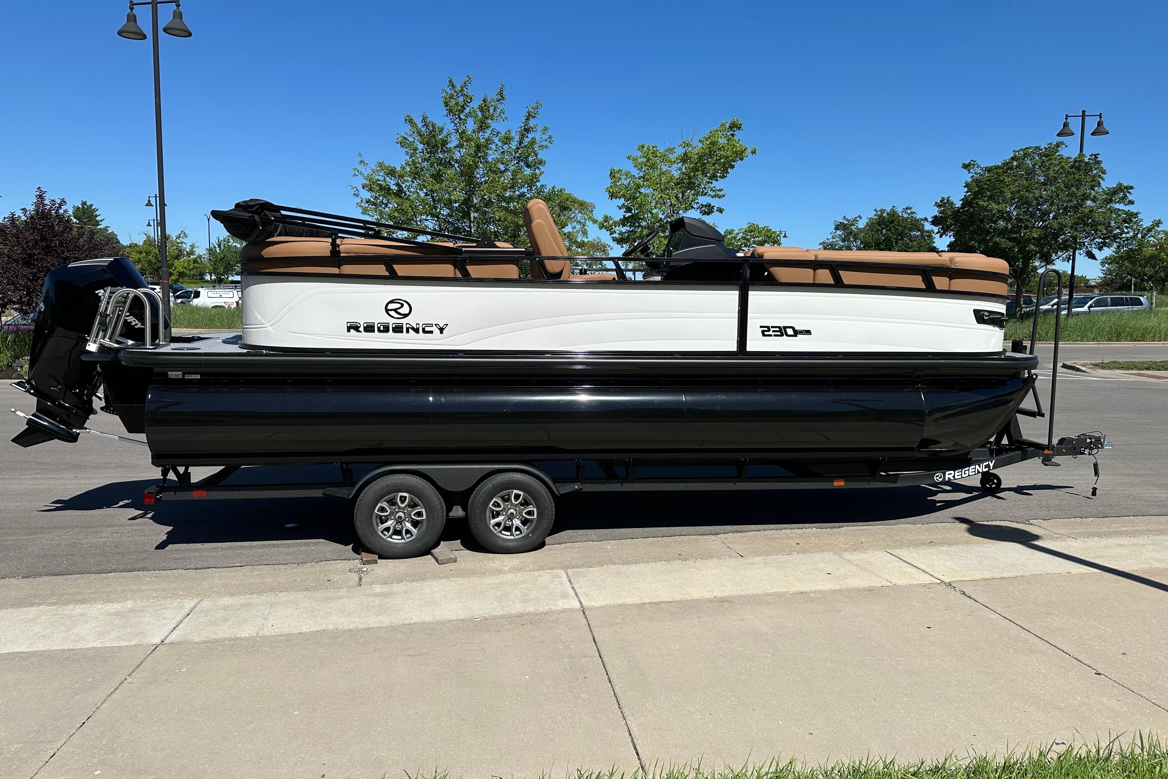 2026 Regency 230 DL pontoon boat on trailer, parked on street, sunny day.