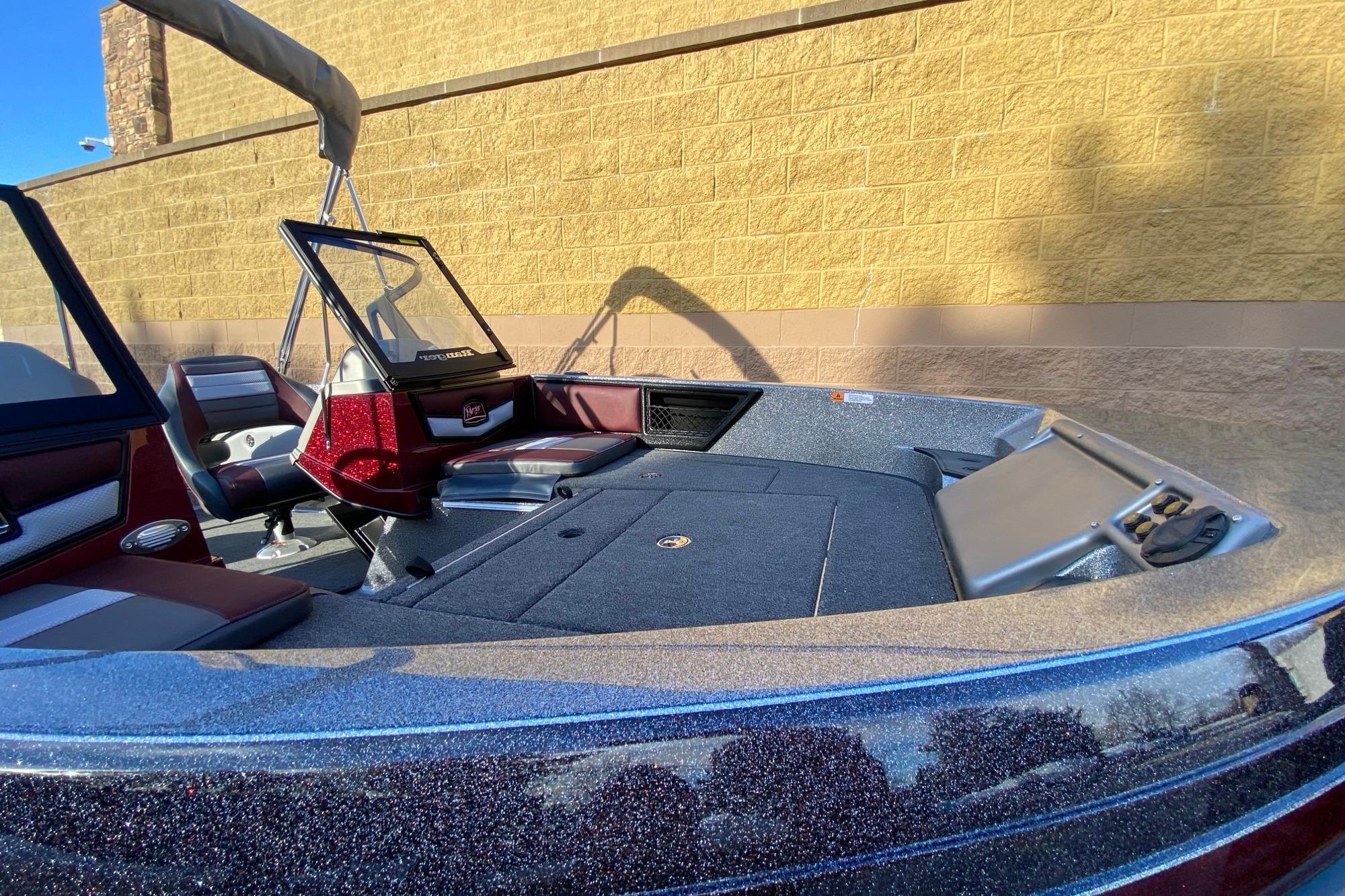 2026 Ranger 1850MS boat interior with seating and windshield, parked by a brick wall.
