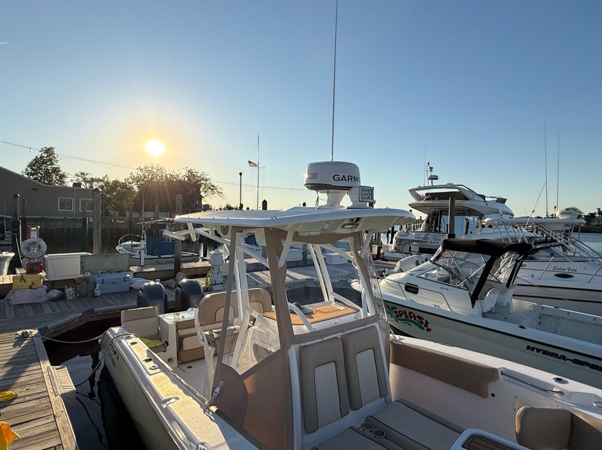 A 2017 Sea Fox Commander 266 docked at sunset, surrounded by other boats.