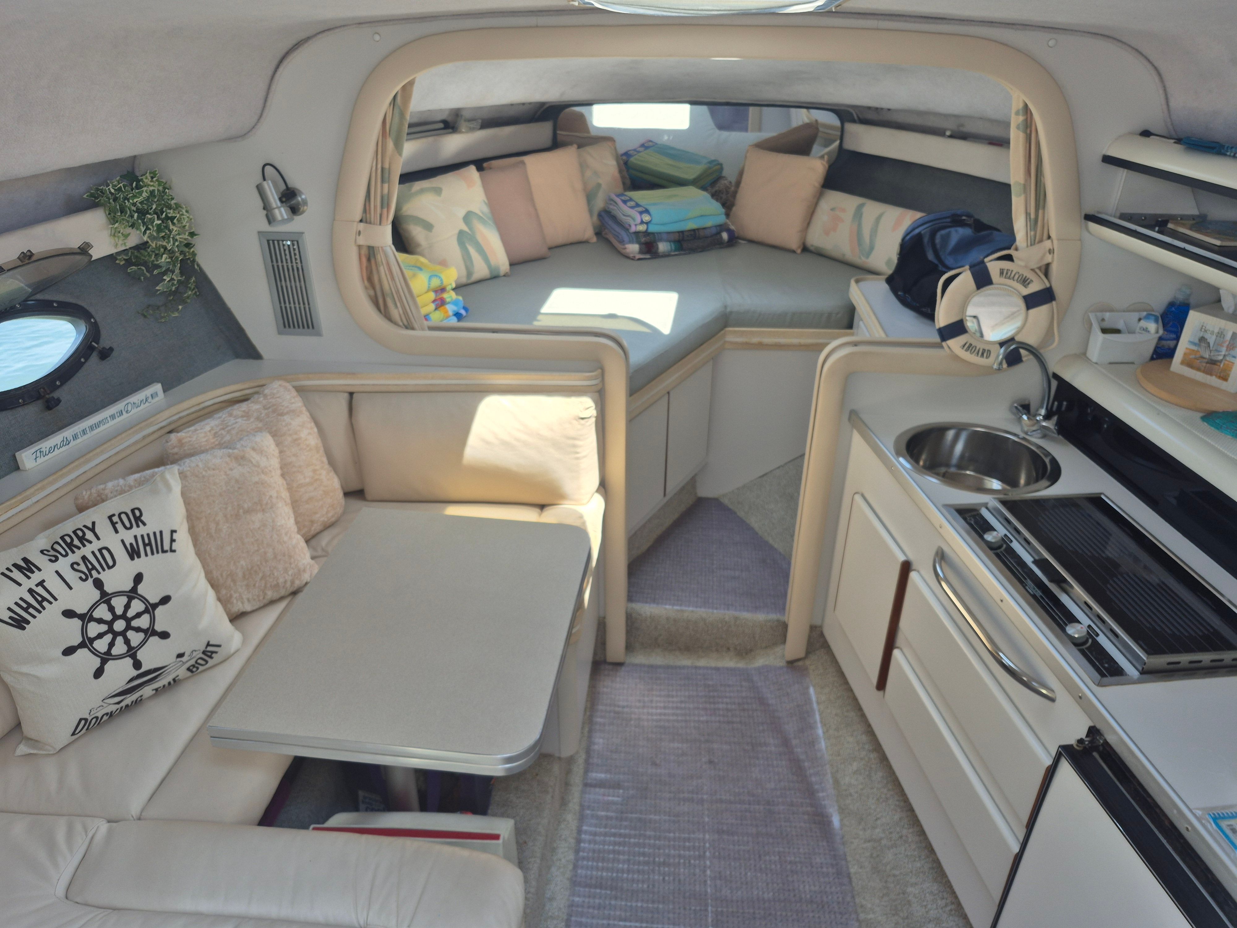 Interior of a 1989 Tiara Yachts Slickcraft with cozy seating area and kitchenette.