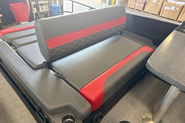 Luxurious seating on 2027 Godfrey Monaco 25' Tritoon with red accents and mid-table flip lounge.