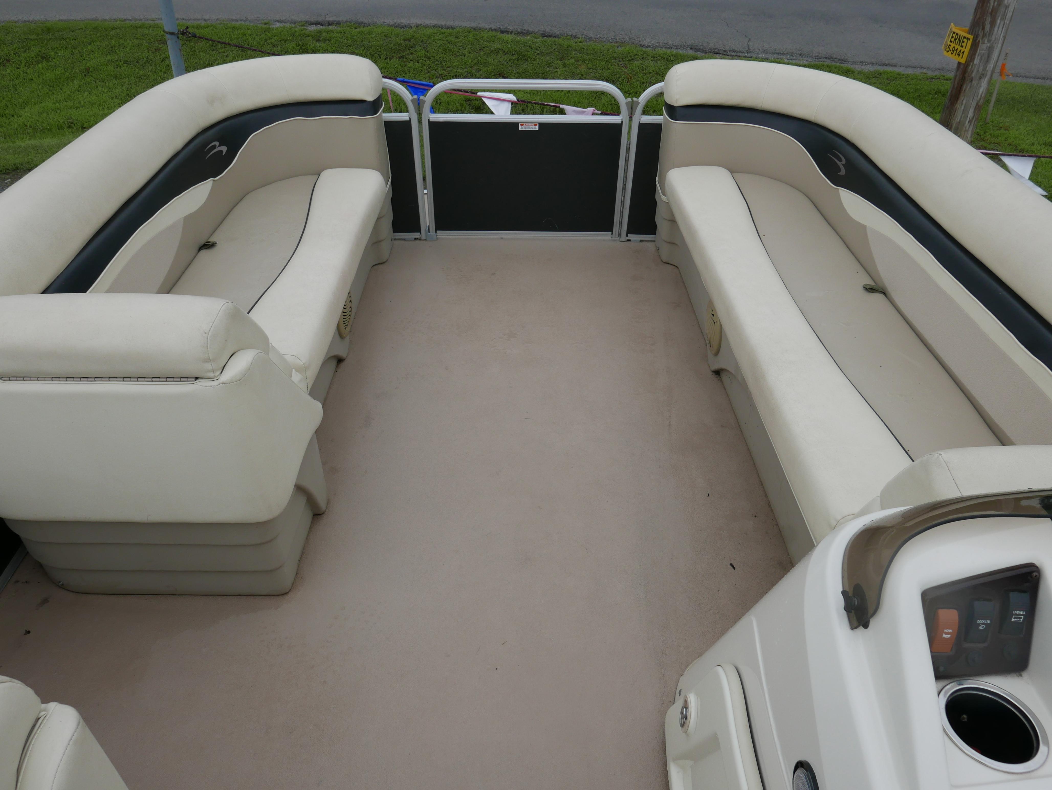 2013 Bennington 22SLX pontoon boat interior with beige seating and spacious layout.