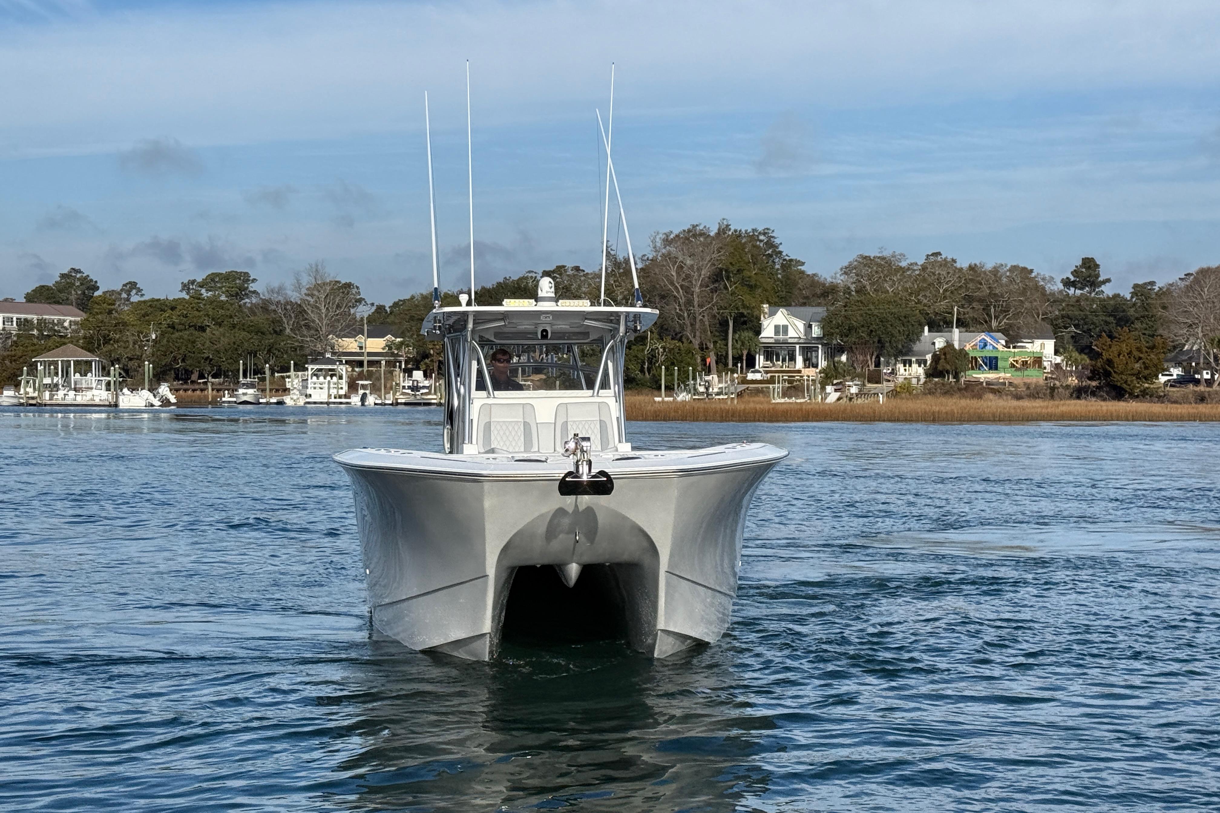 2021 SeaHunter 41 CTS boat cruising on calm waters near a coastal town.