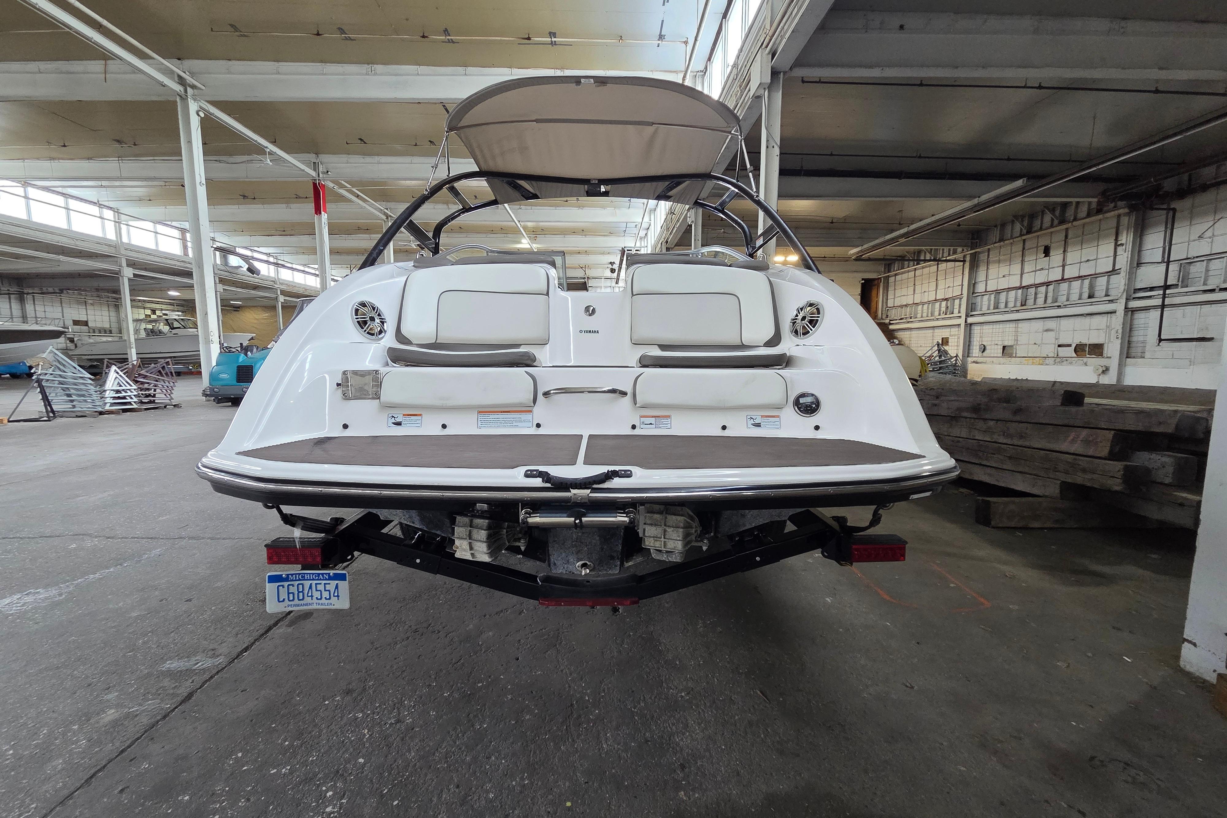 2013 Yamaha 242 Limited S boat in warehouse, rear view with Michigan license plate.