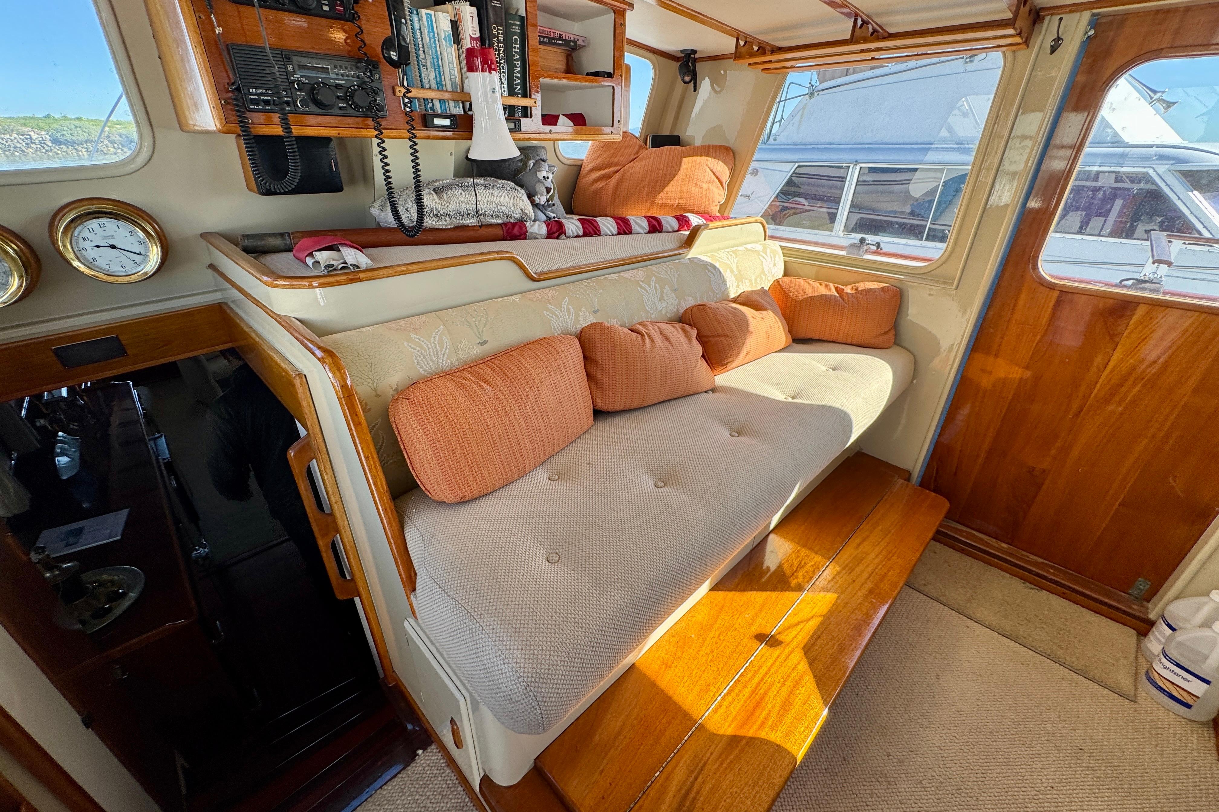 1958 Blanchard Pilothouse interior with cozy seating, wooden accents, and nautical decor.