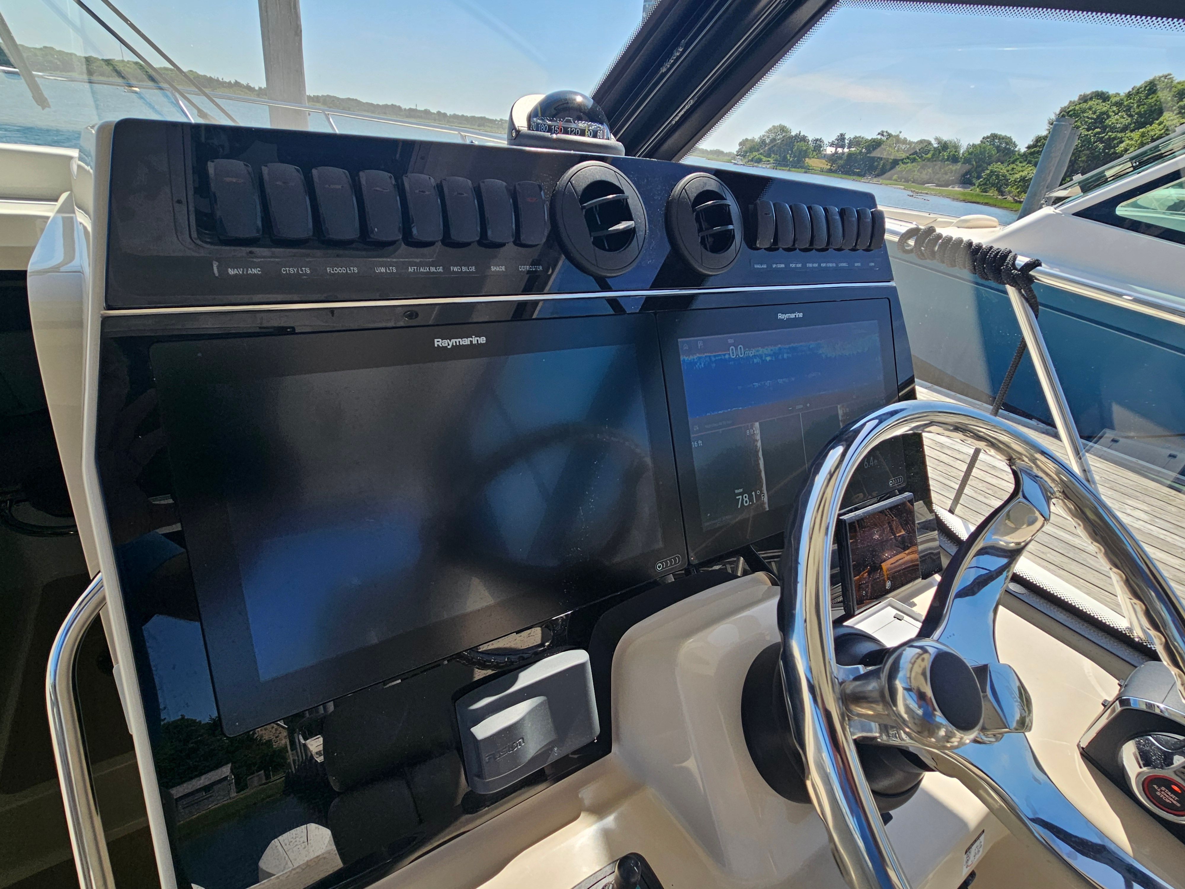 The cockpit of the 2023 Boston Whaler 325 Conquest features modern navigation systems and a sleek steering wheel.