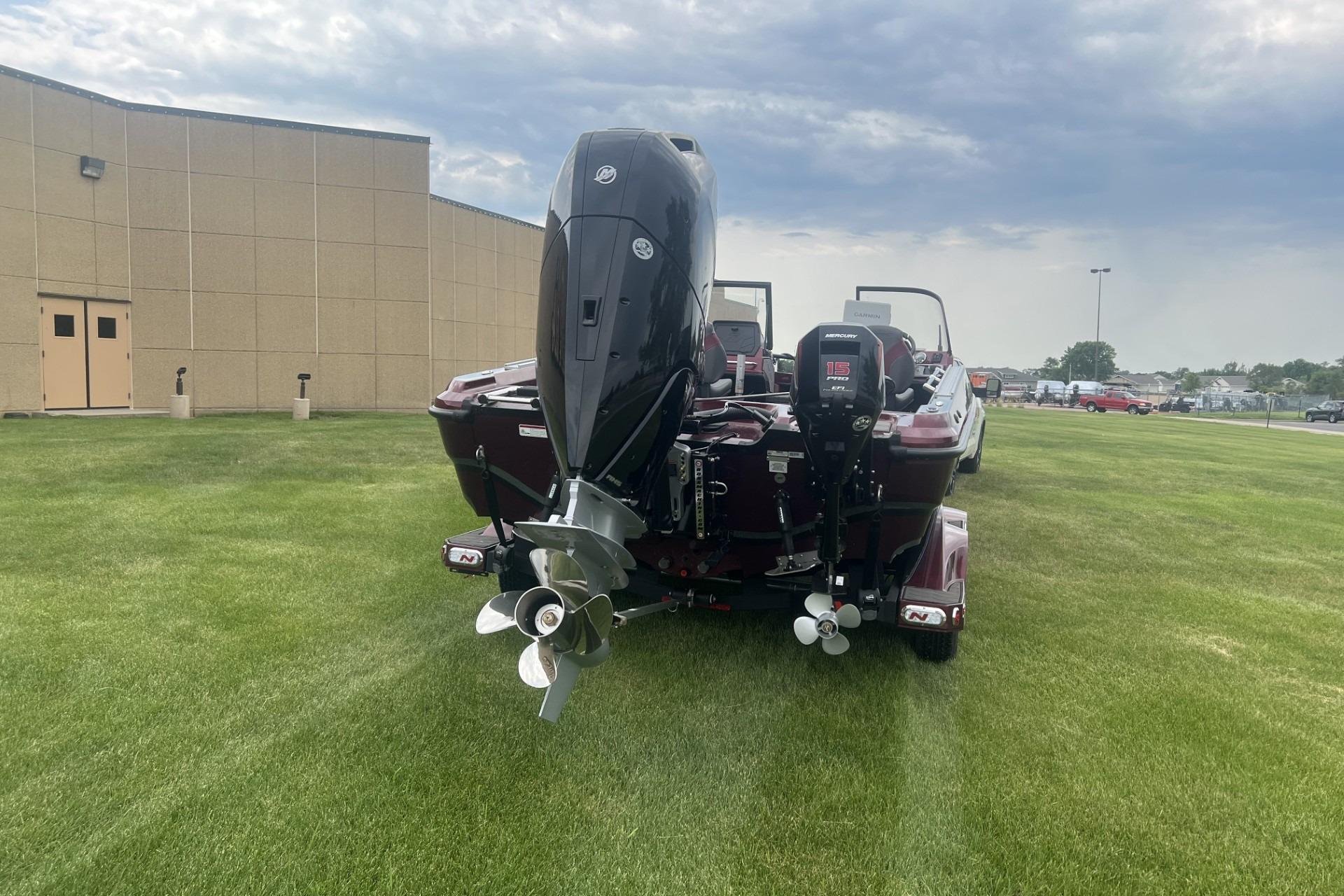 2026 Nitro ZV21 Pro boat with dual outboard motors on grassy field.