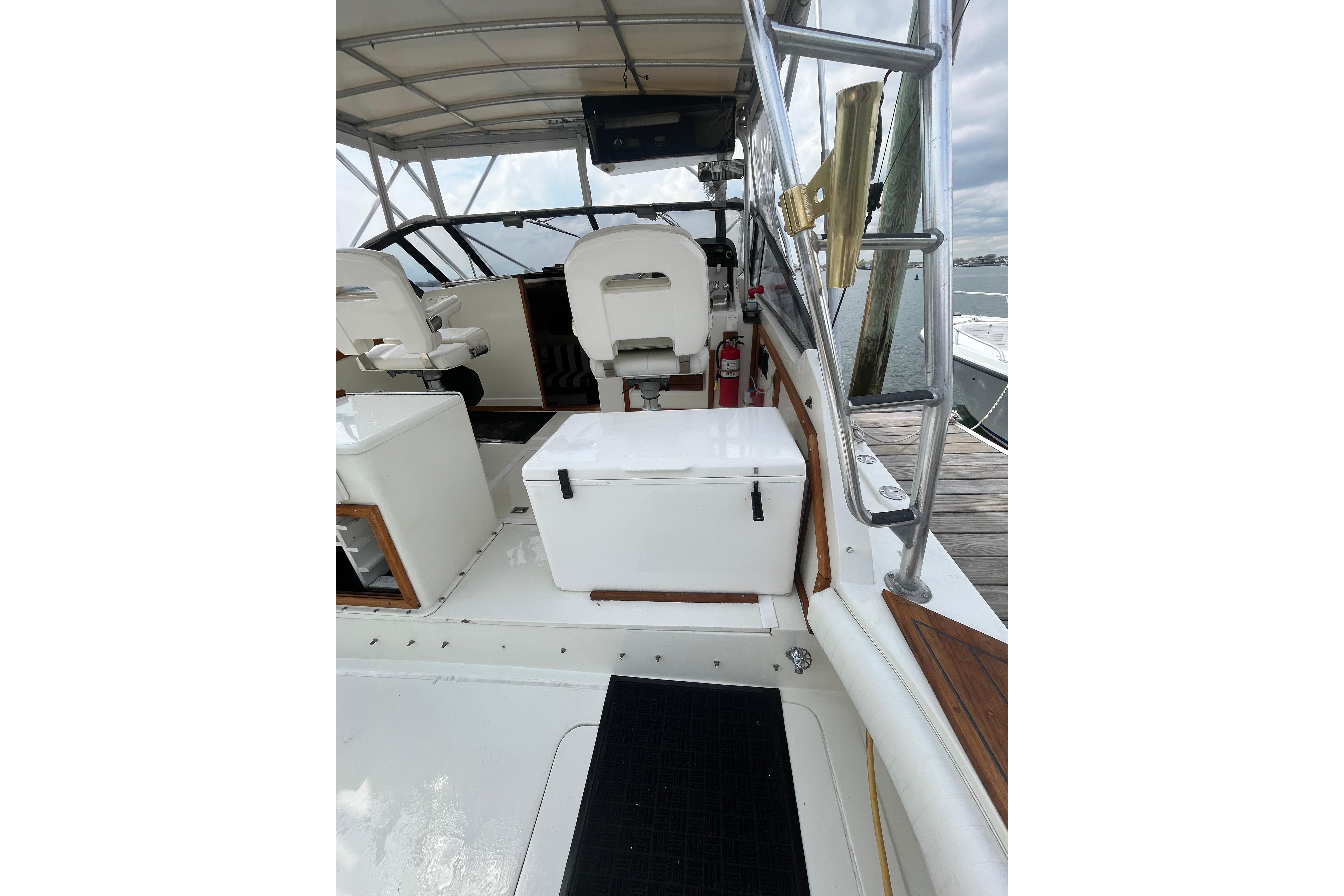 1989 Blackfin 31 Combi boat interior with seating and cooler on deck.