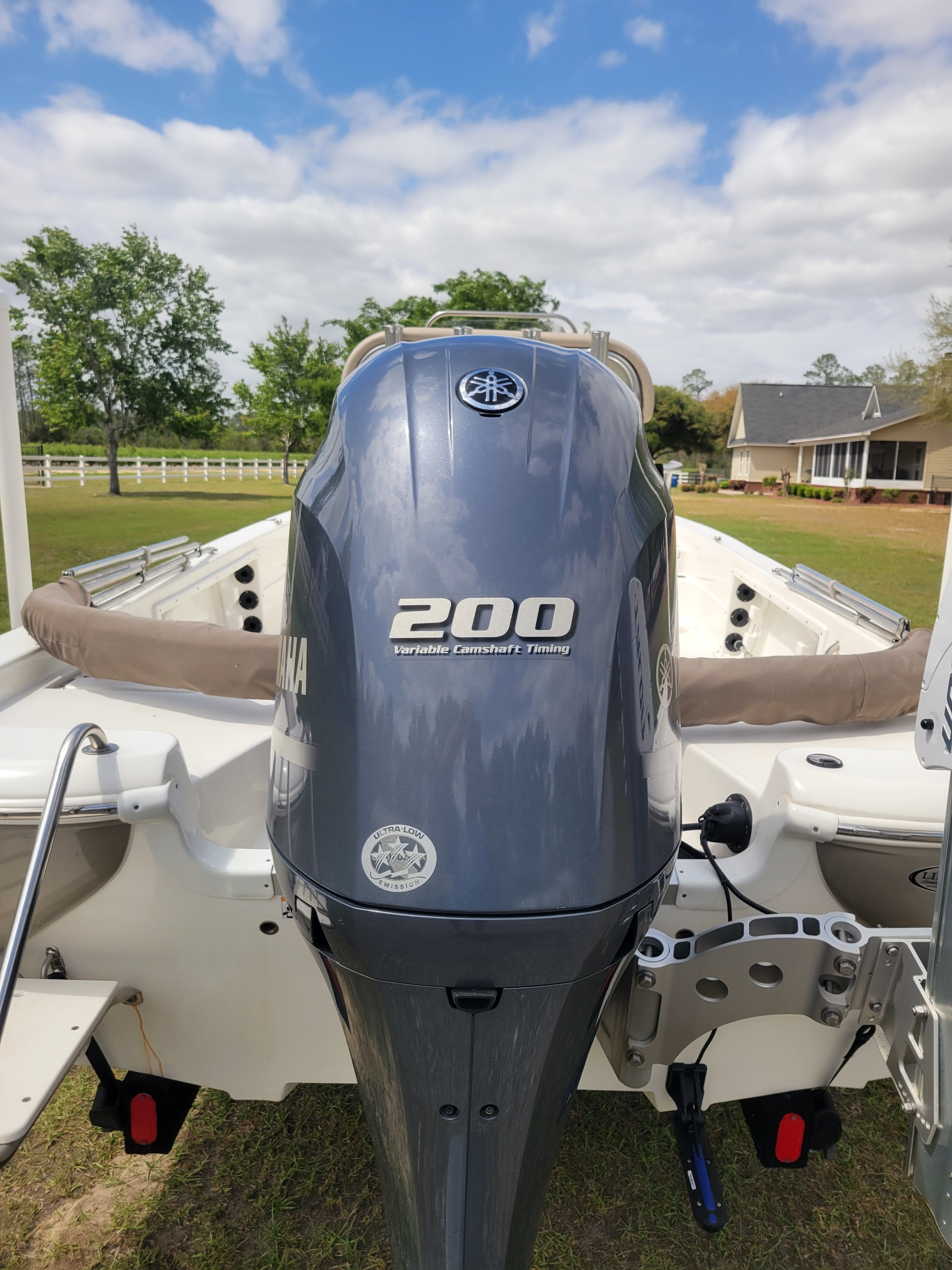 A NauticStar 2200 Sport boat with a Yamaha 200 outboard motor on a lawn.