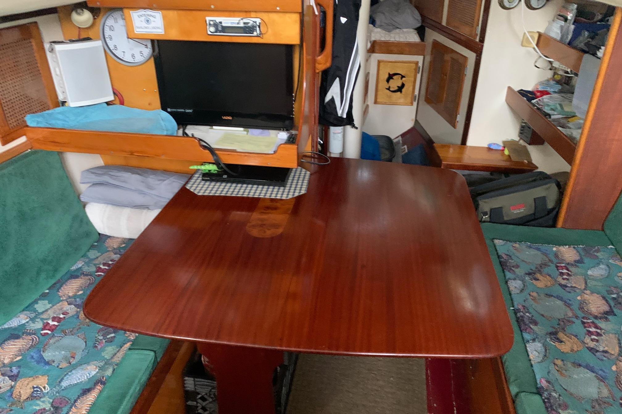 1960 Rhodes Bounty interior with wooden table, seating, and nautical decor.
