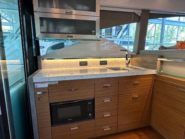Modern kitchen area in a 2019 Tiara Yachts C53, featuring sleek cabinetry and built-in appliances.