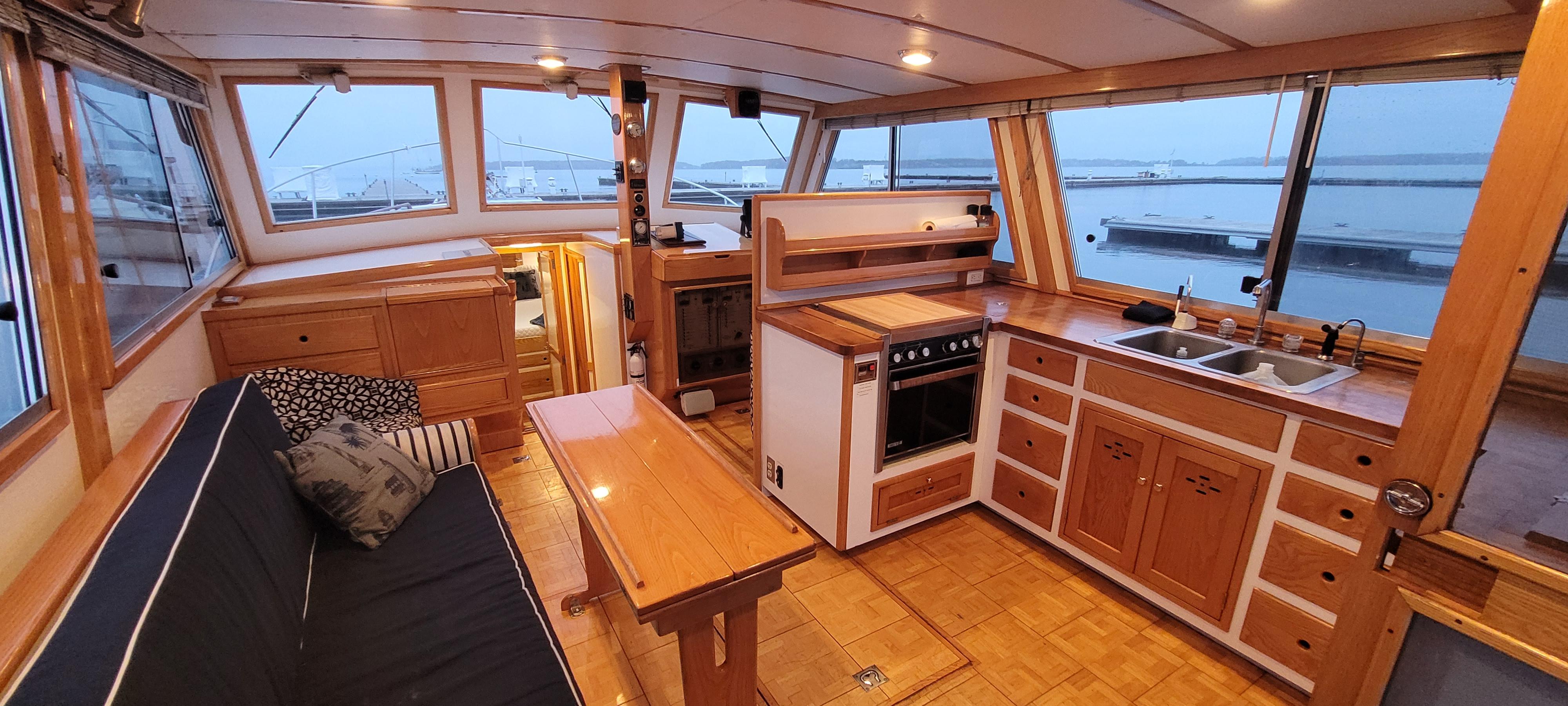 1989 Duffy Wilbur 42 Flybridge Cruiser interior with wood finish, kitchen, and seating area.