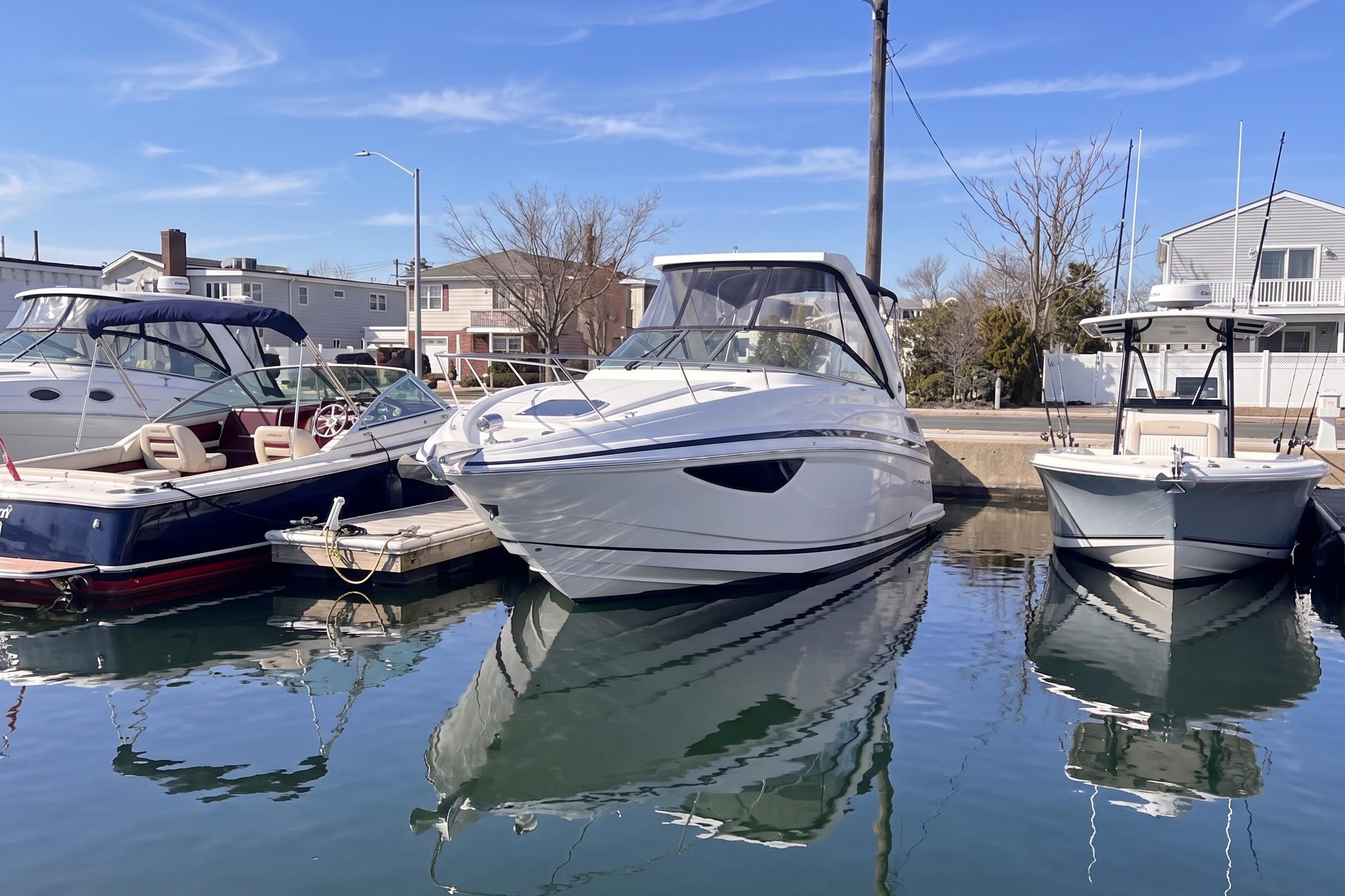 2017 Regal 28 Express boat docked between two other boats in a marina.