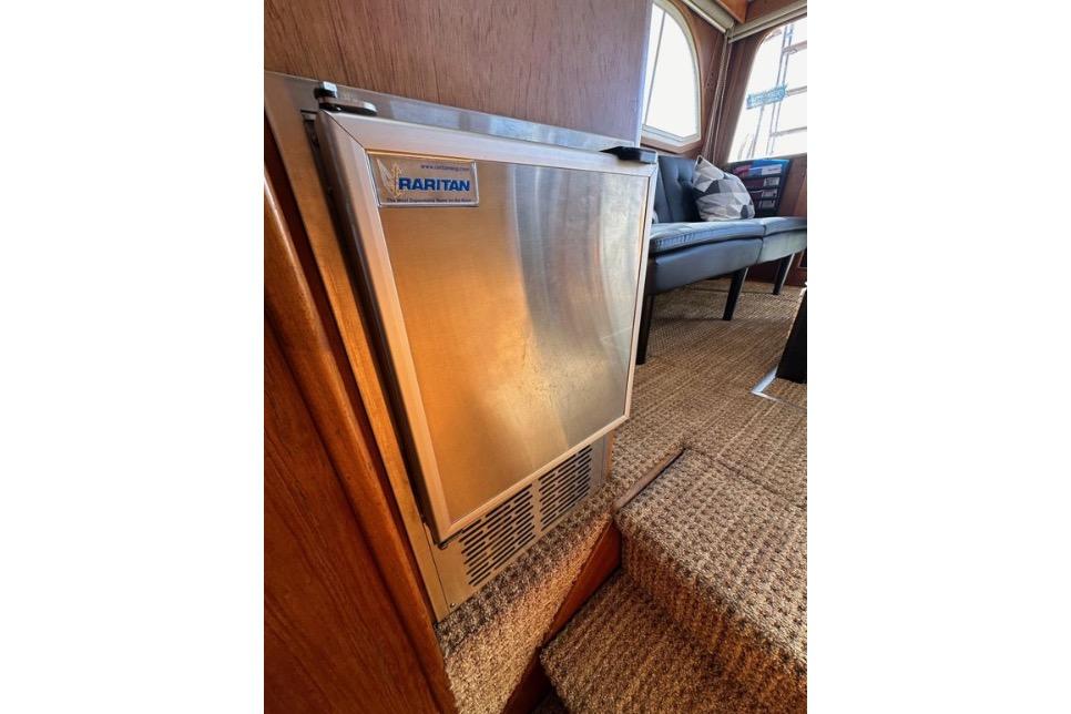 Raritan refrigerator inside 1985 Egg Harbor 33 Sedan yacht, with carpeted steps and seating area.