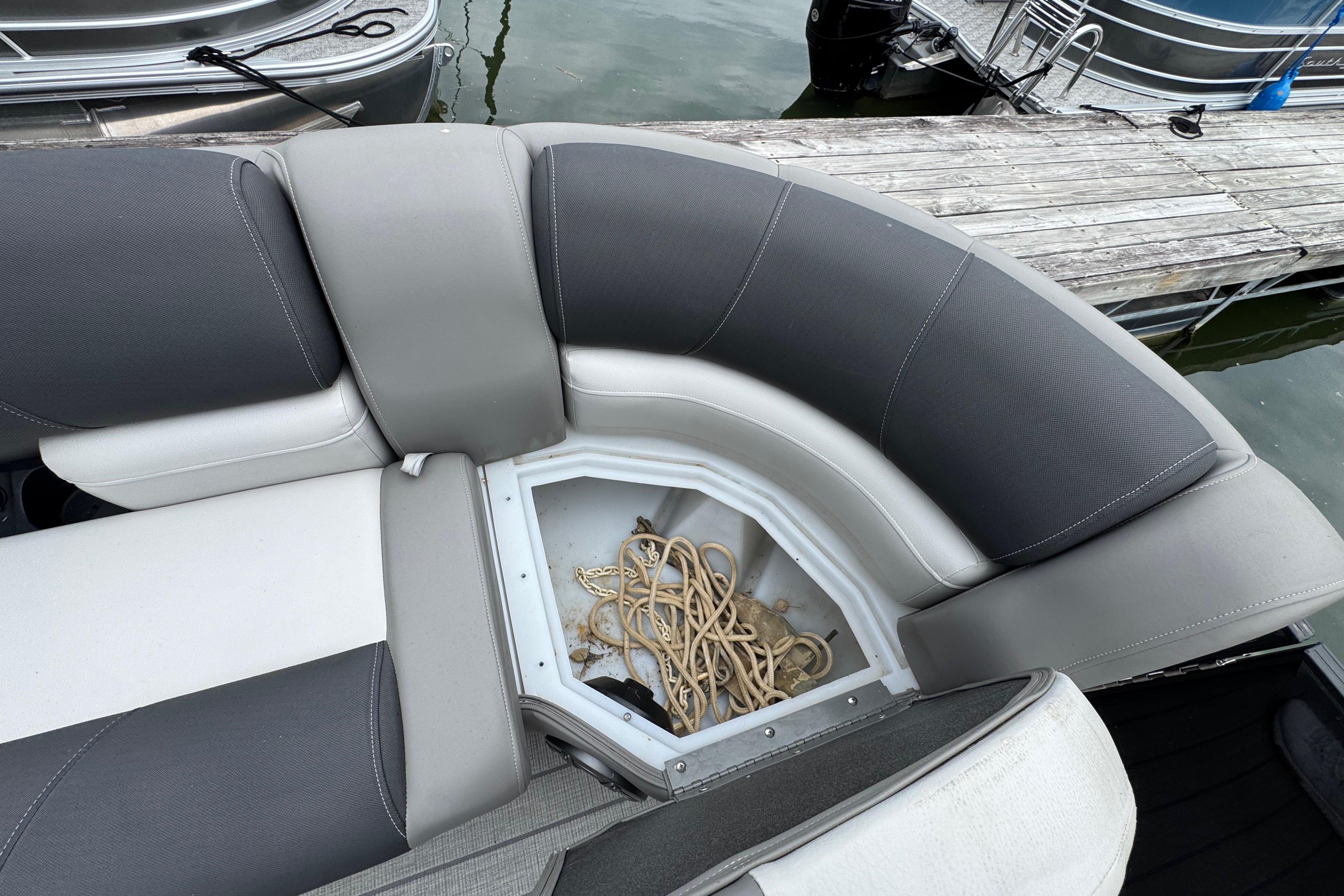 2023 Starcraft MX 25 DL DH boat seating with storage compartment and rope.