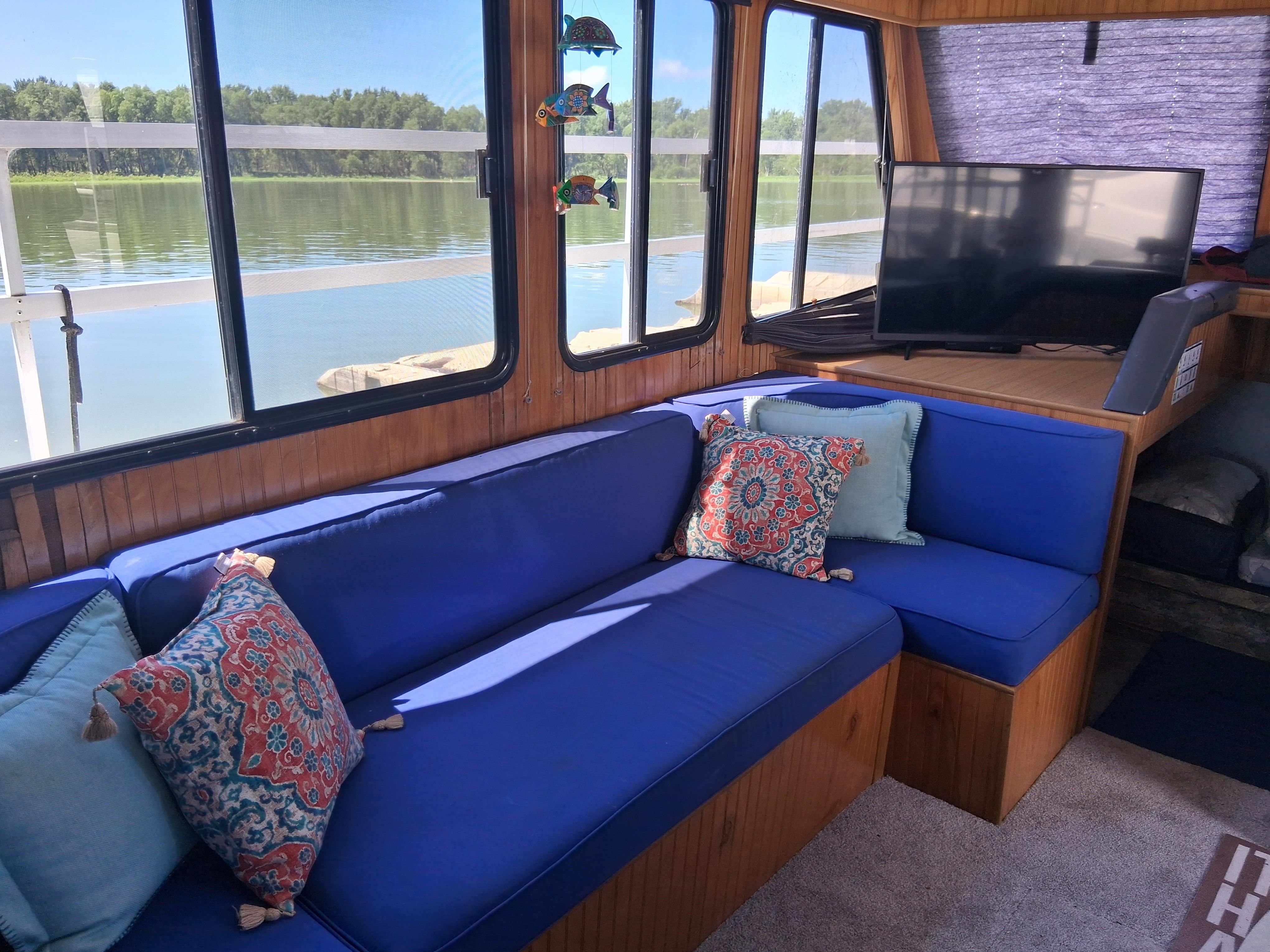 The interior of a 1993 Gibson 370 Sport features a cozy seating area with blue cushions.