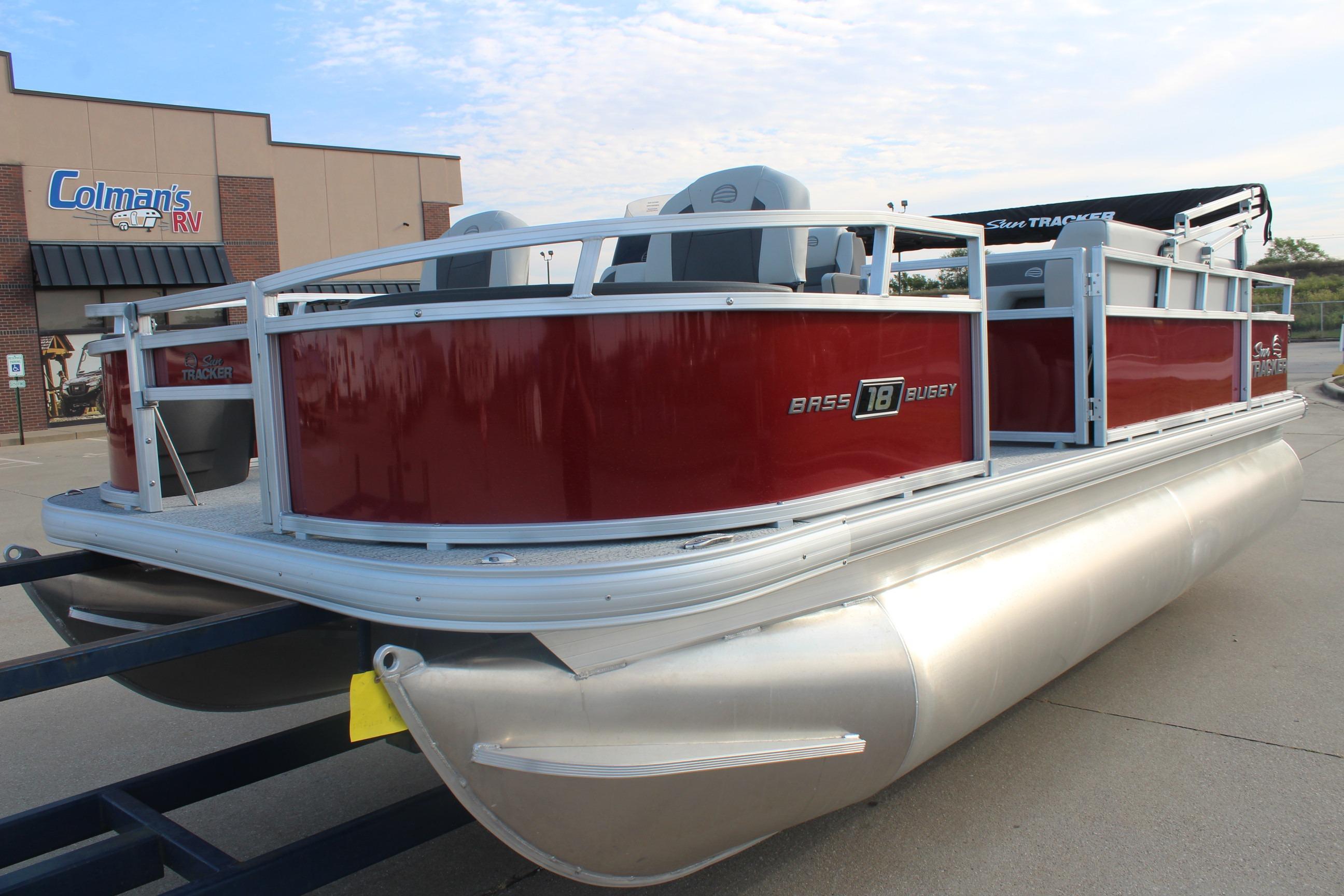 2026 Sun Tracker Bass Buggy 18 DLX pontoon boat in a parking lot.