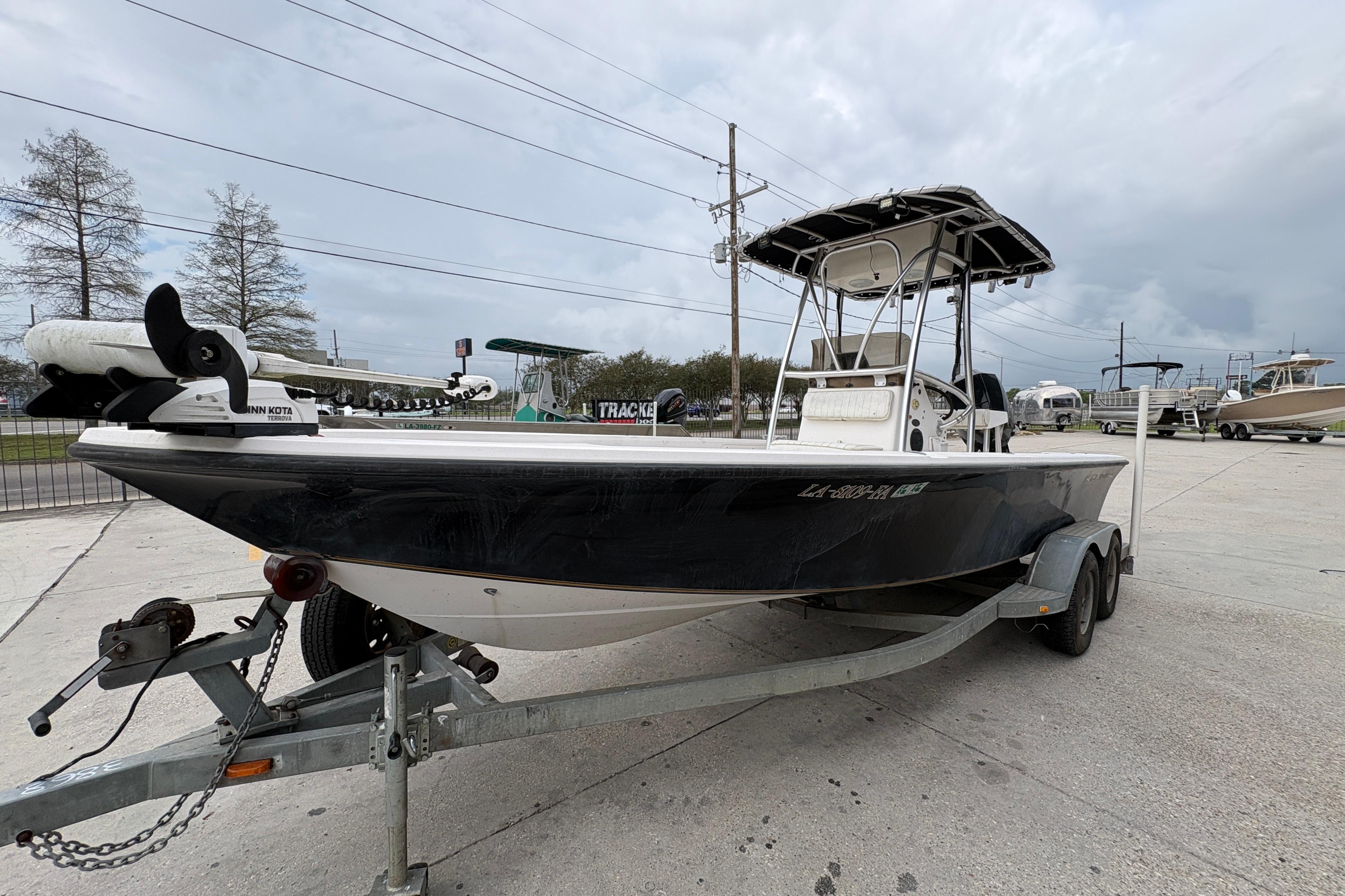 2000 Kenner 21 VISION boat on trailer, parked outdoors under cloudy sky.