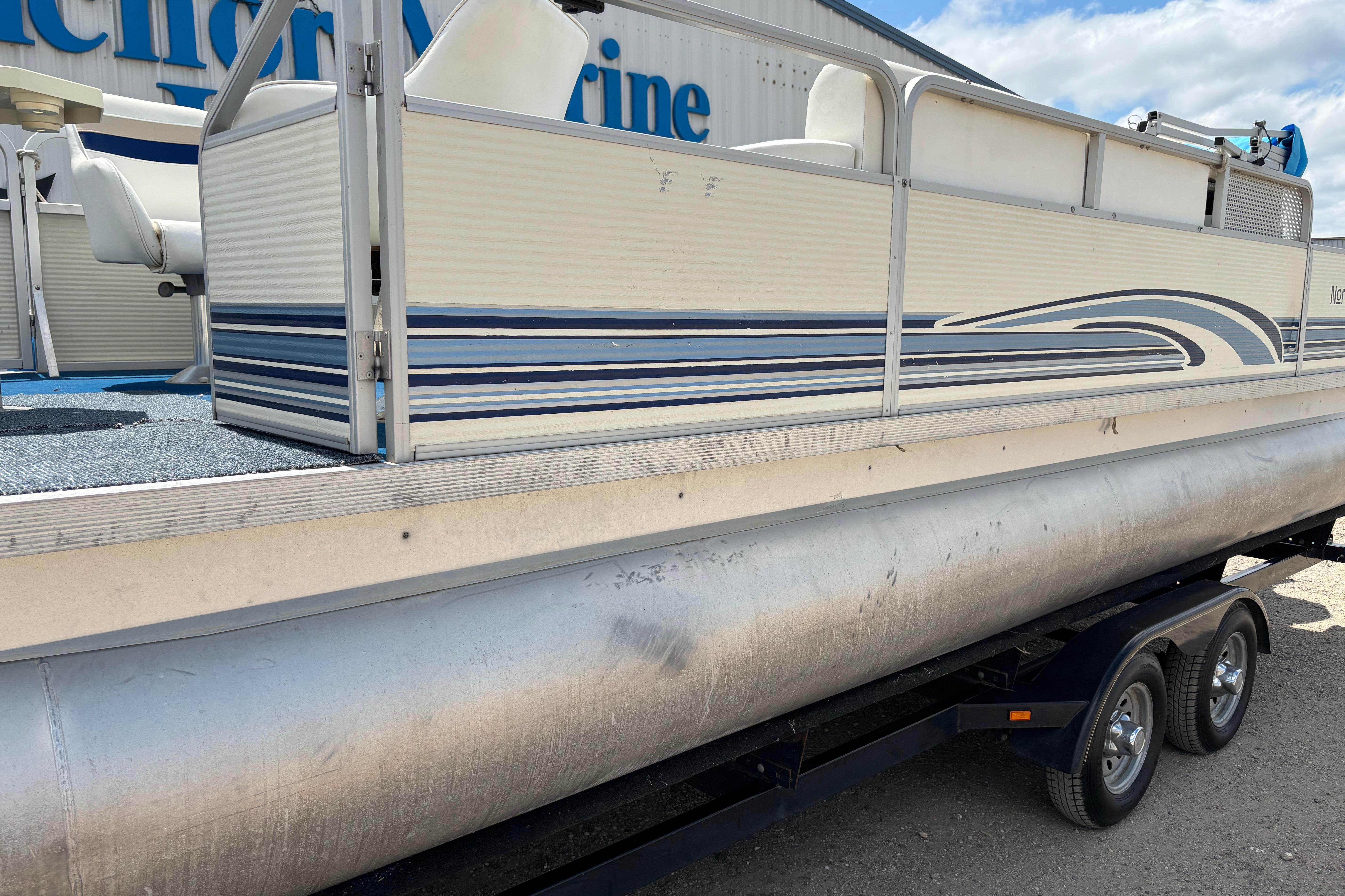 1997 Northwood 24' Pontoon boat on trailer, featuring blue and white design.