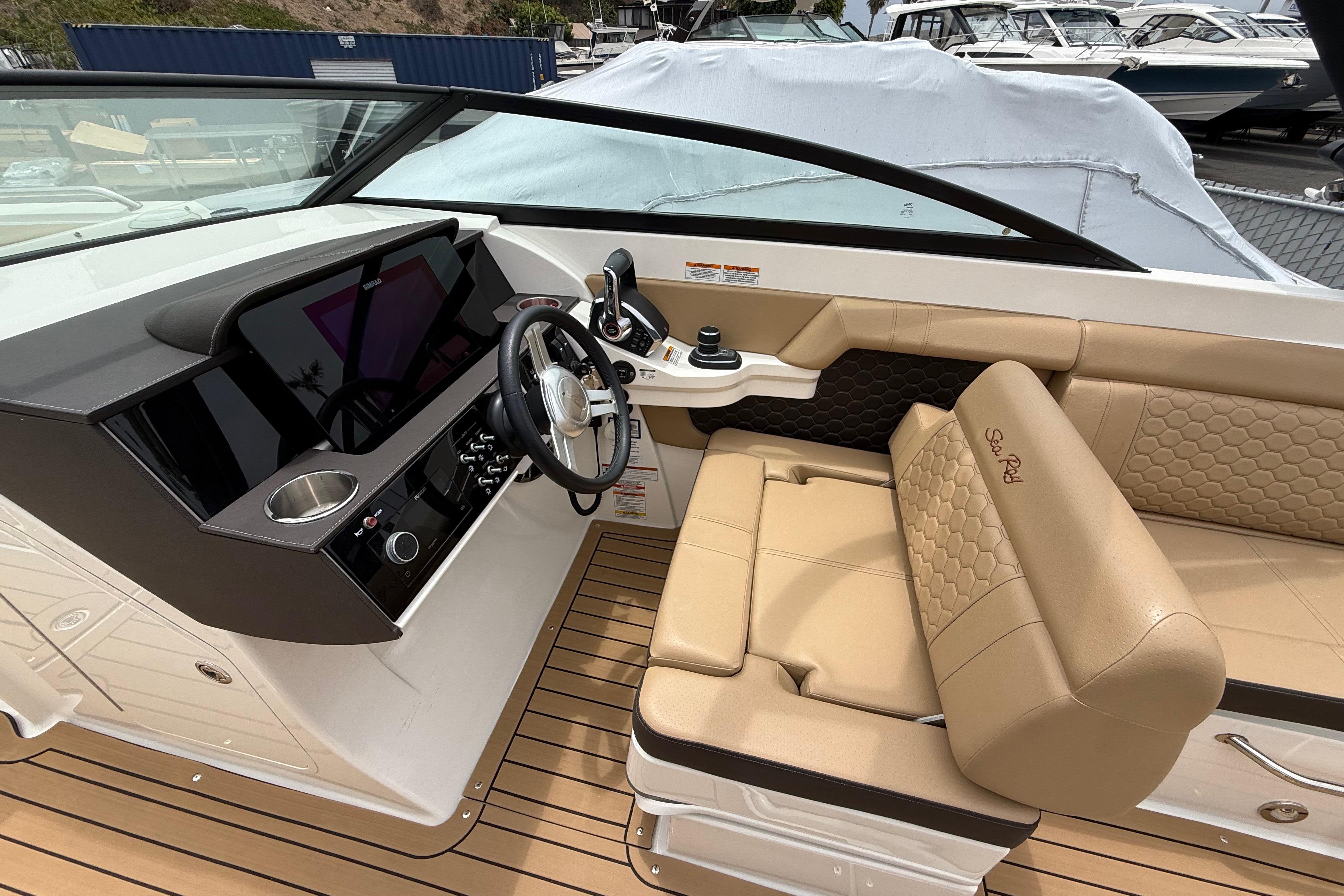 2022 Sea Ray SDX 290 Outboard helm with tan seating and modern dashboard.