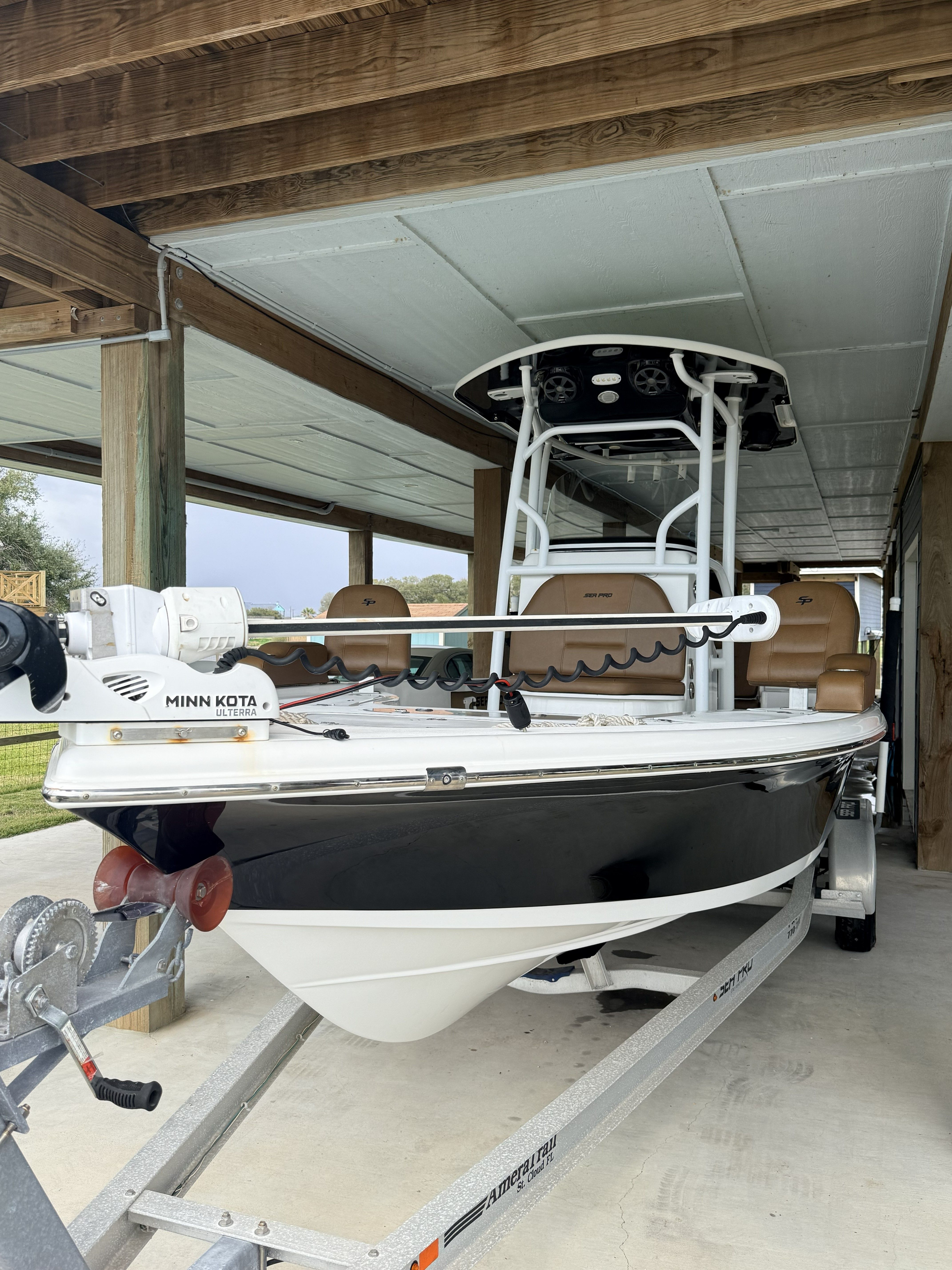 A 2018 Sea Pro 248 Bay boat is on a trailer under a carport.