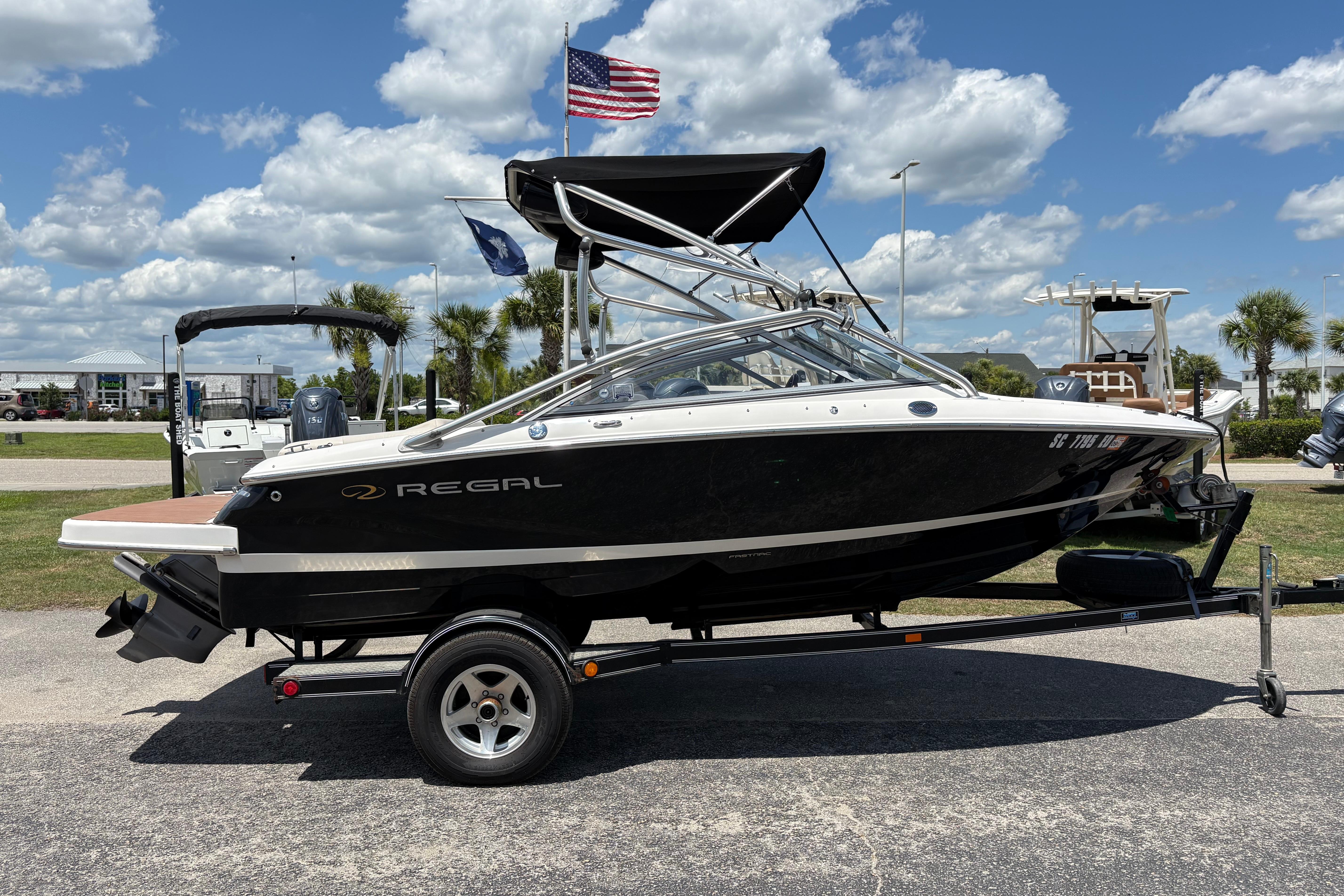 2008 Regal 1900 Bowrider boat on trailer, parked outdoors under a blue sky.