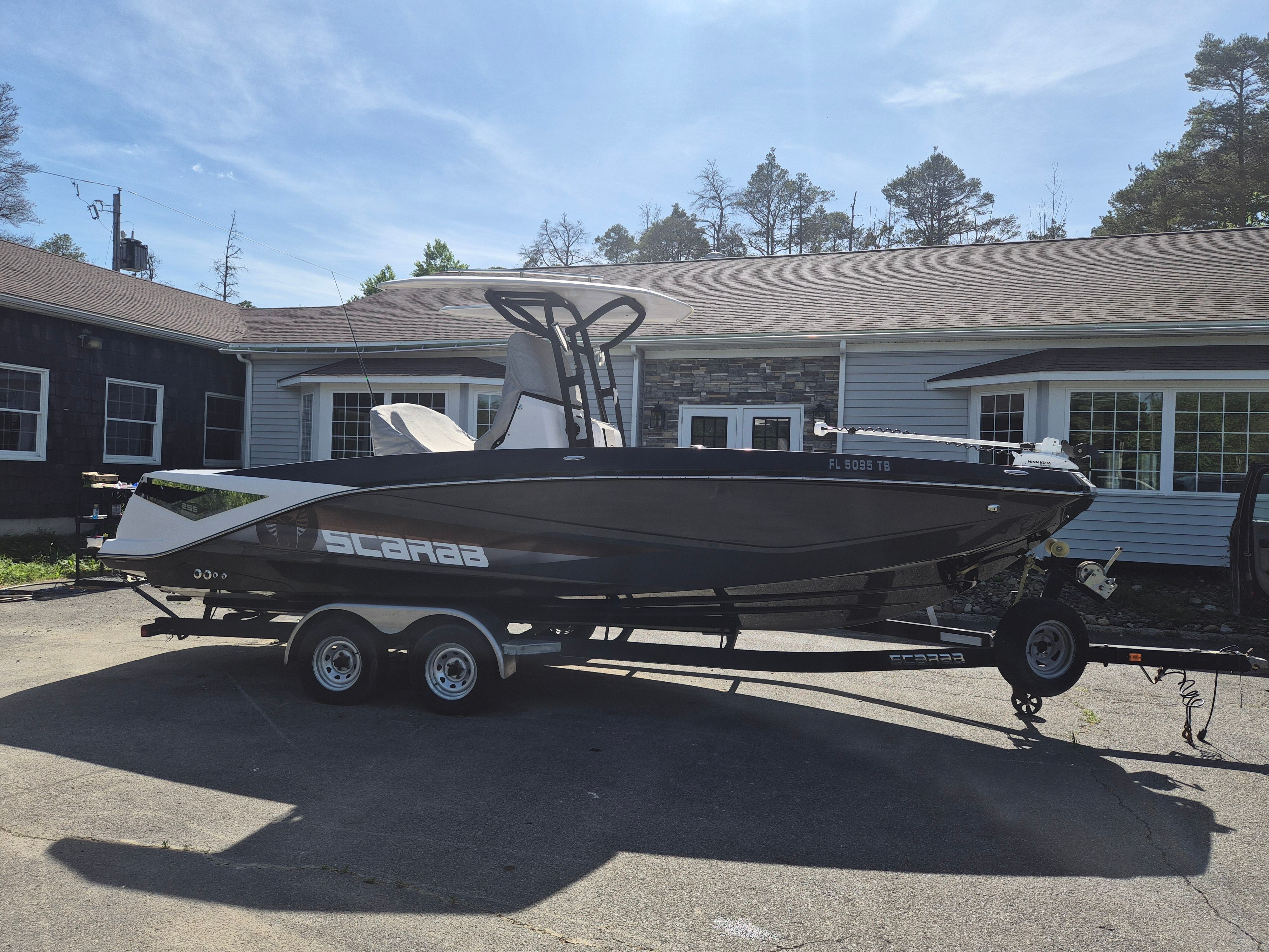 2019 Scarab 255 Open ID boat on trailer in front of house.