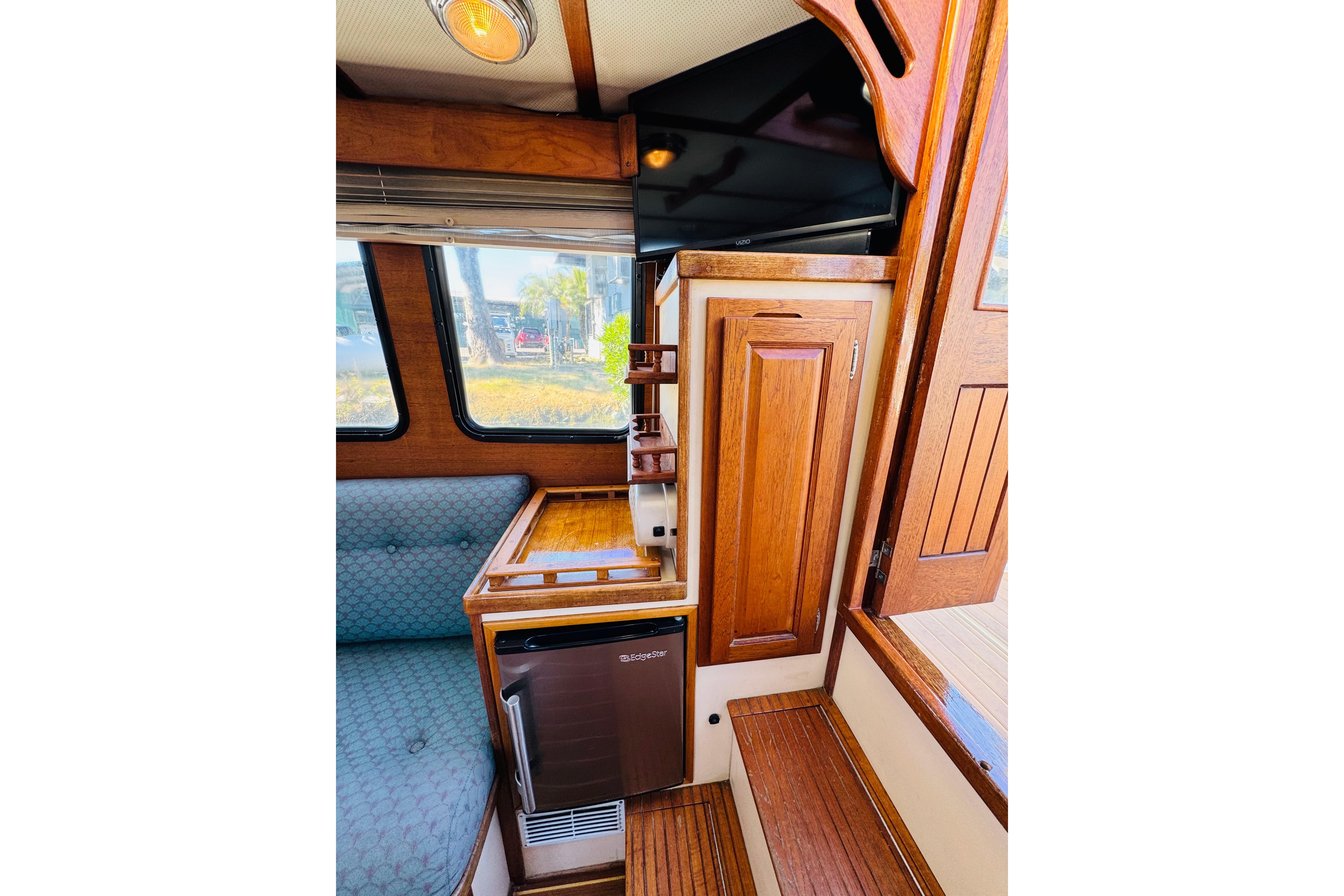 Interior of a 1996 Nordic Tug 32, featuring wood cabinetry and seating area.