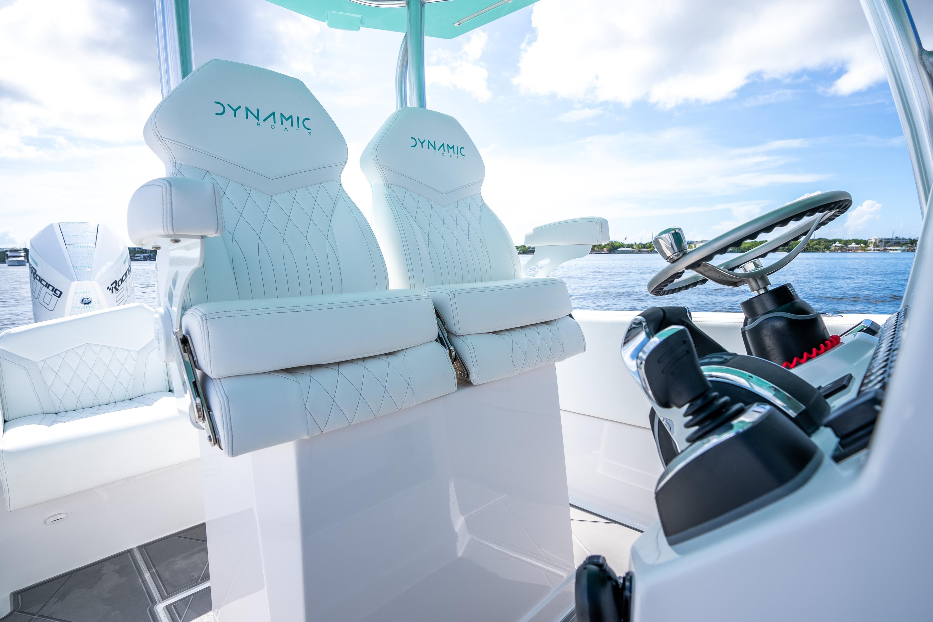 2024 Dynamic D-305V boat interior with white leather seats and modern steering controls.