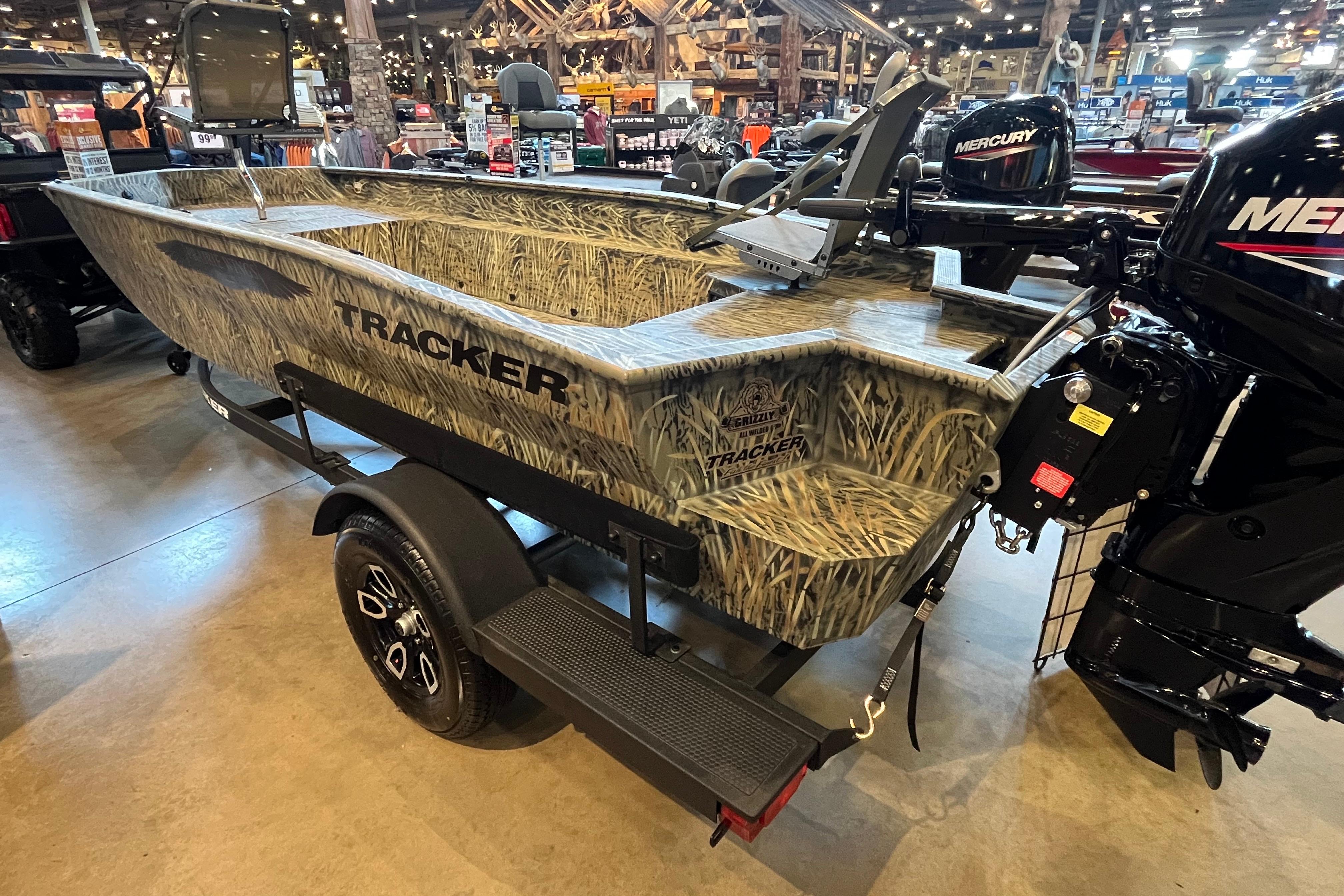 2026 Tracker Grizzly 1650 T Prairie Wings Edition boat with camouflage design in showroom.