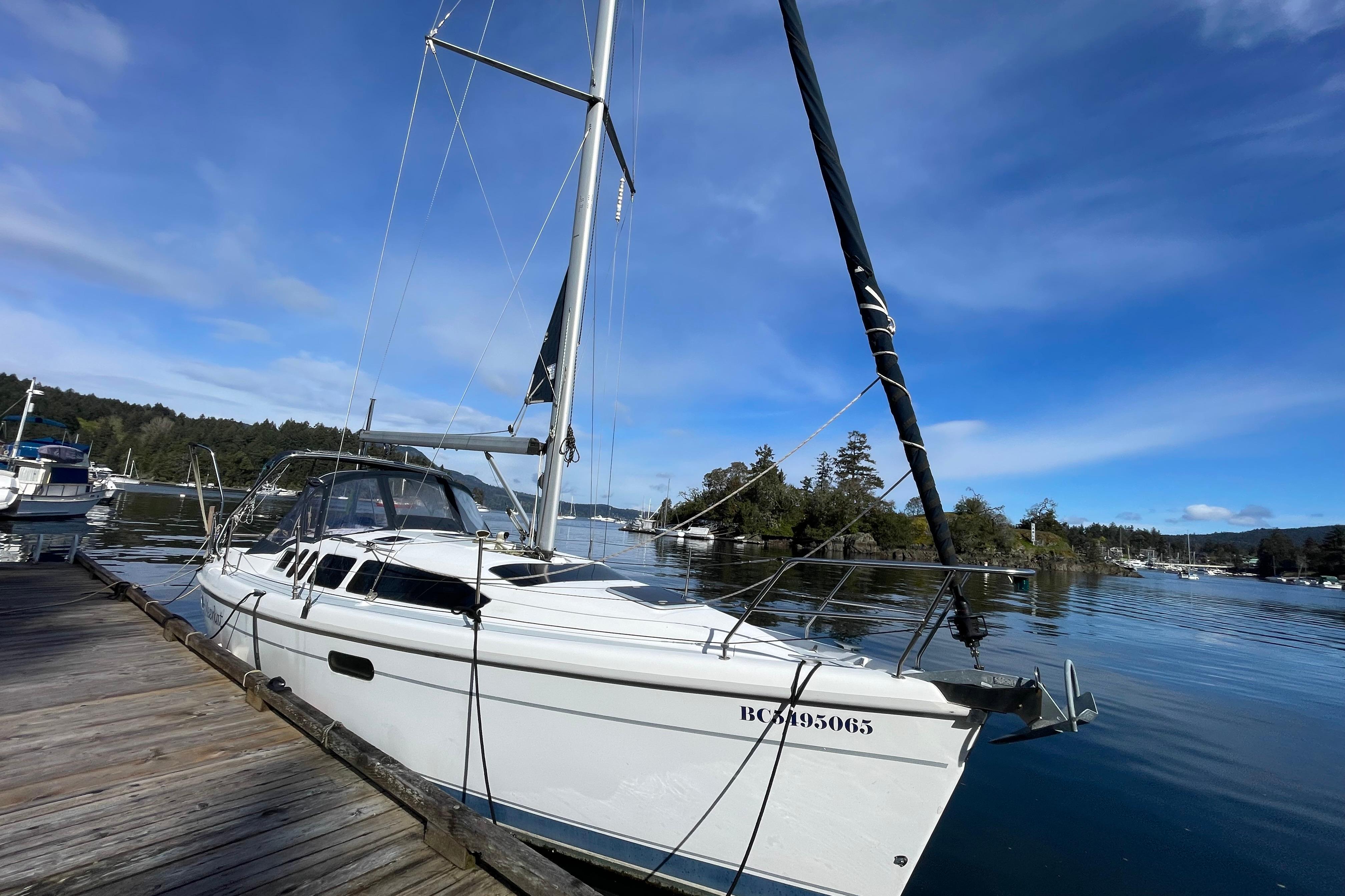 Sailboat docked on calm water, 2000 Hunter 340 model, under a clear blue sky.