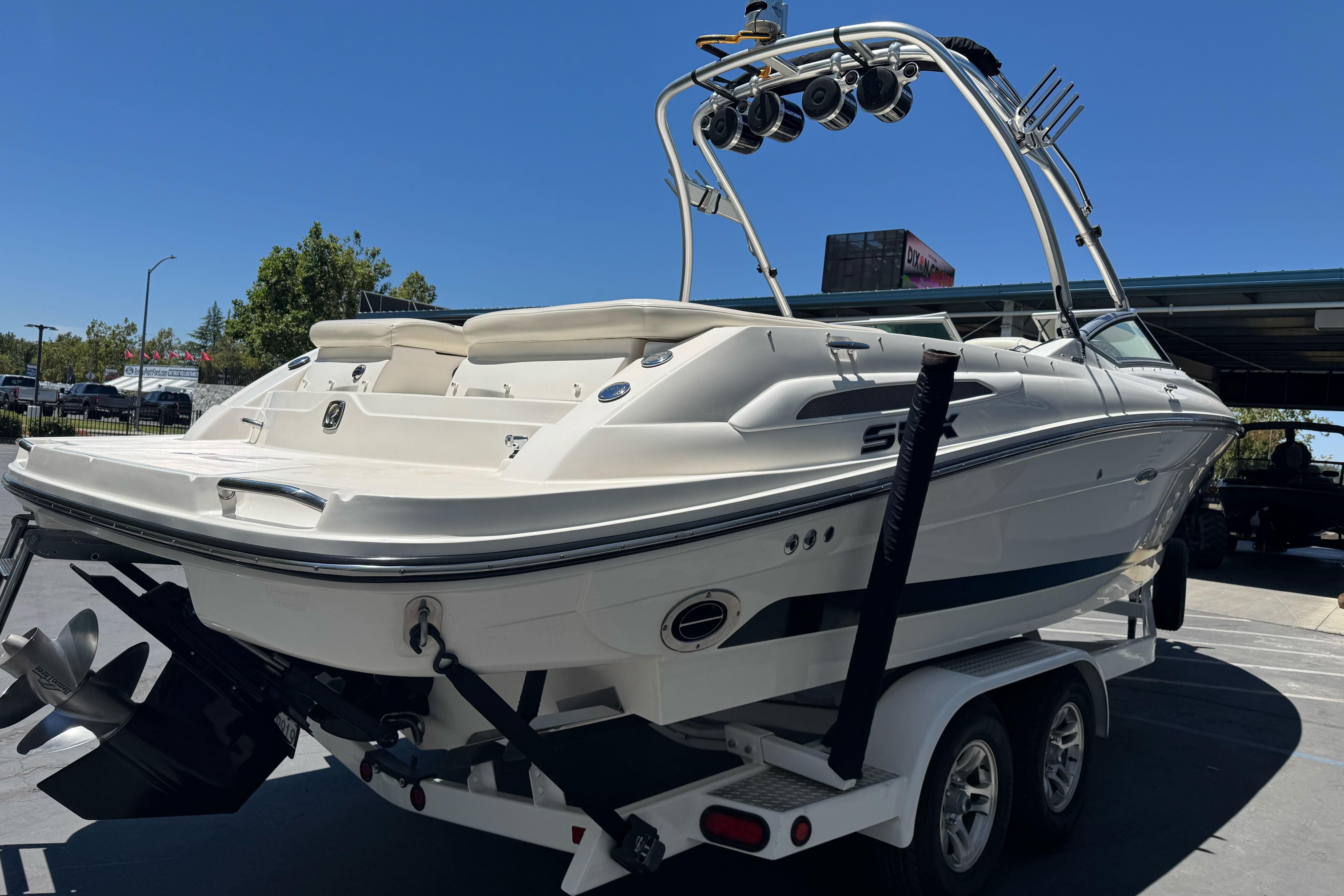 2007 Sea Ray SLX 250 boat on trailer, rear view, under clear blue sky.