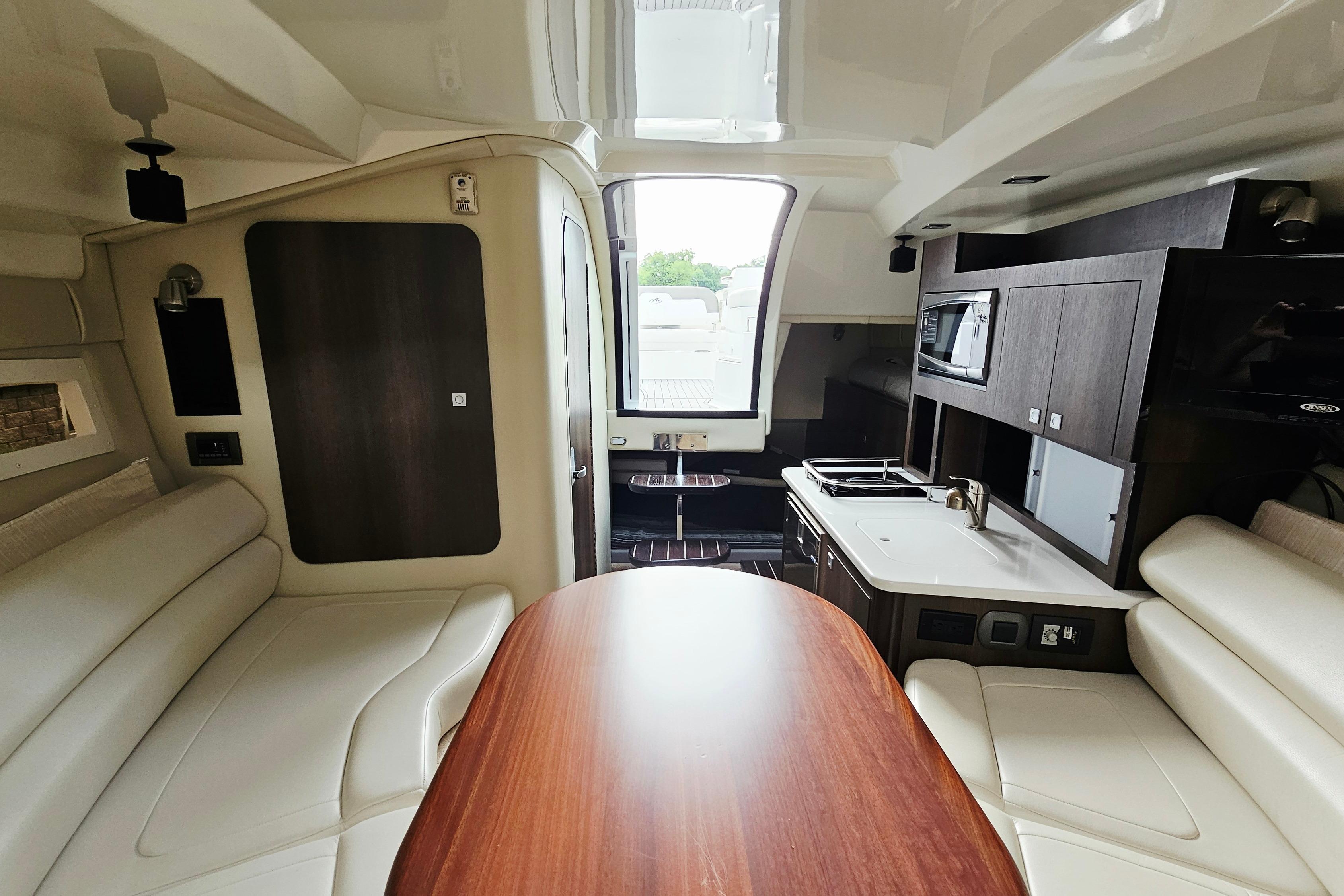 Interior of 2016 Monterey 295 Sport Yacht with modern kitchen and seating area.