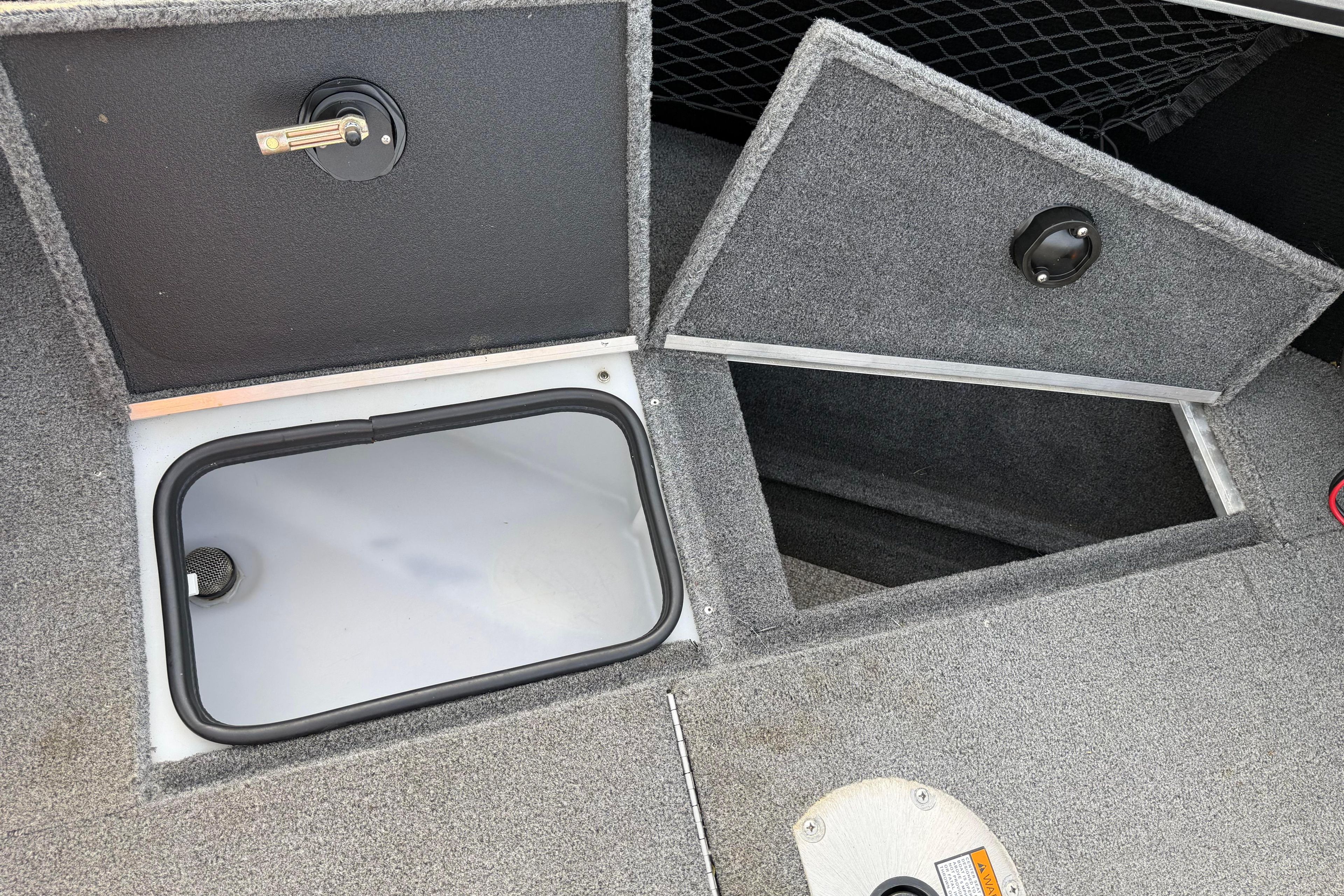 2019 Alumacraft Trophy 205 boat storage compartments with open hatches and carpeted interior.